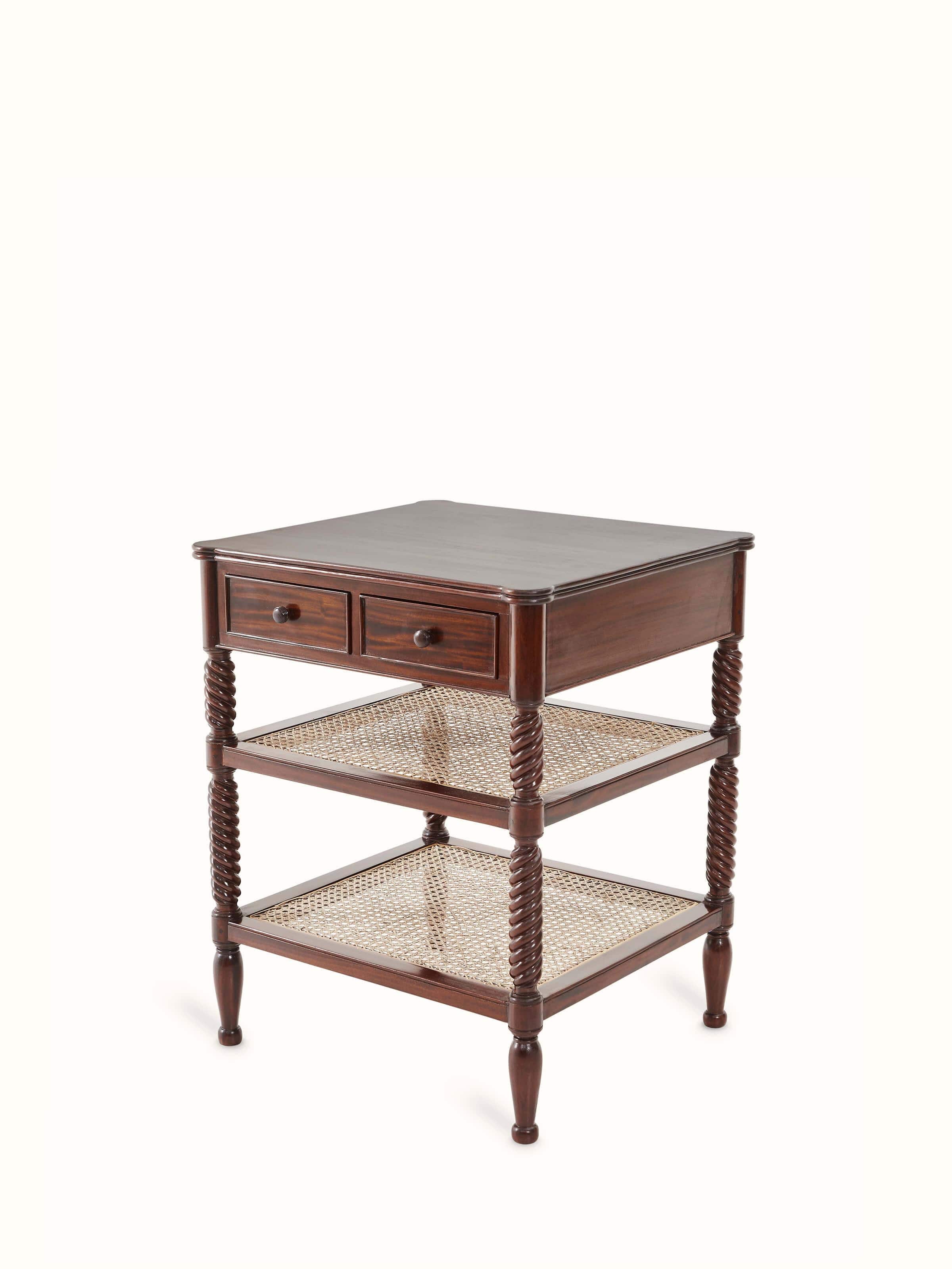 Close-up of the mahogany wood and cane bedside table, showing the intricate cane detailing and polished wood surface.