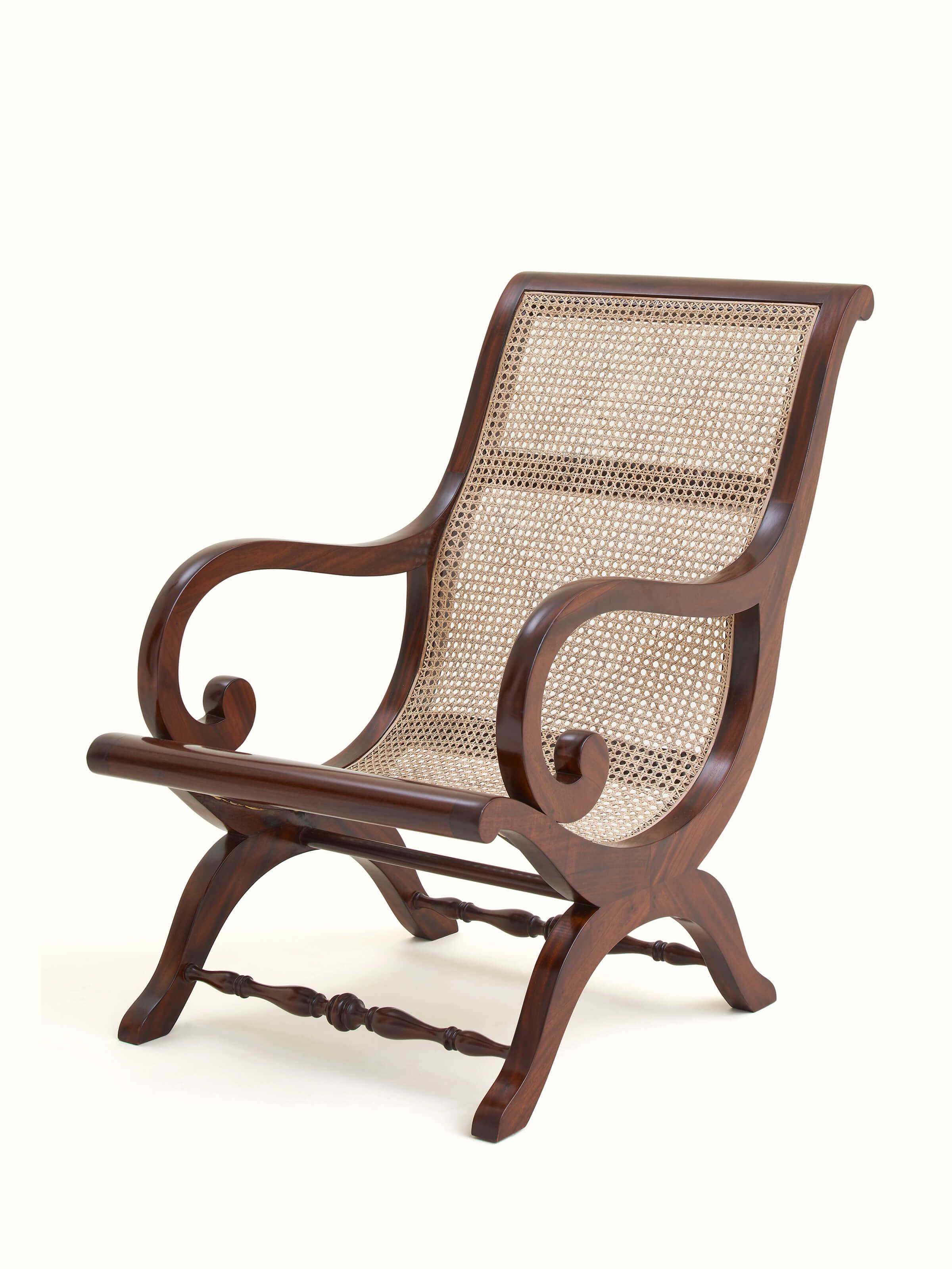 Angled view of Mahogany wood & cane wing chair, emphasizing the comfortable design and detailed cane patterns