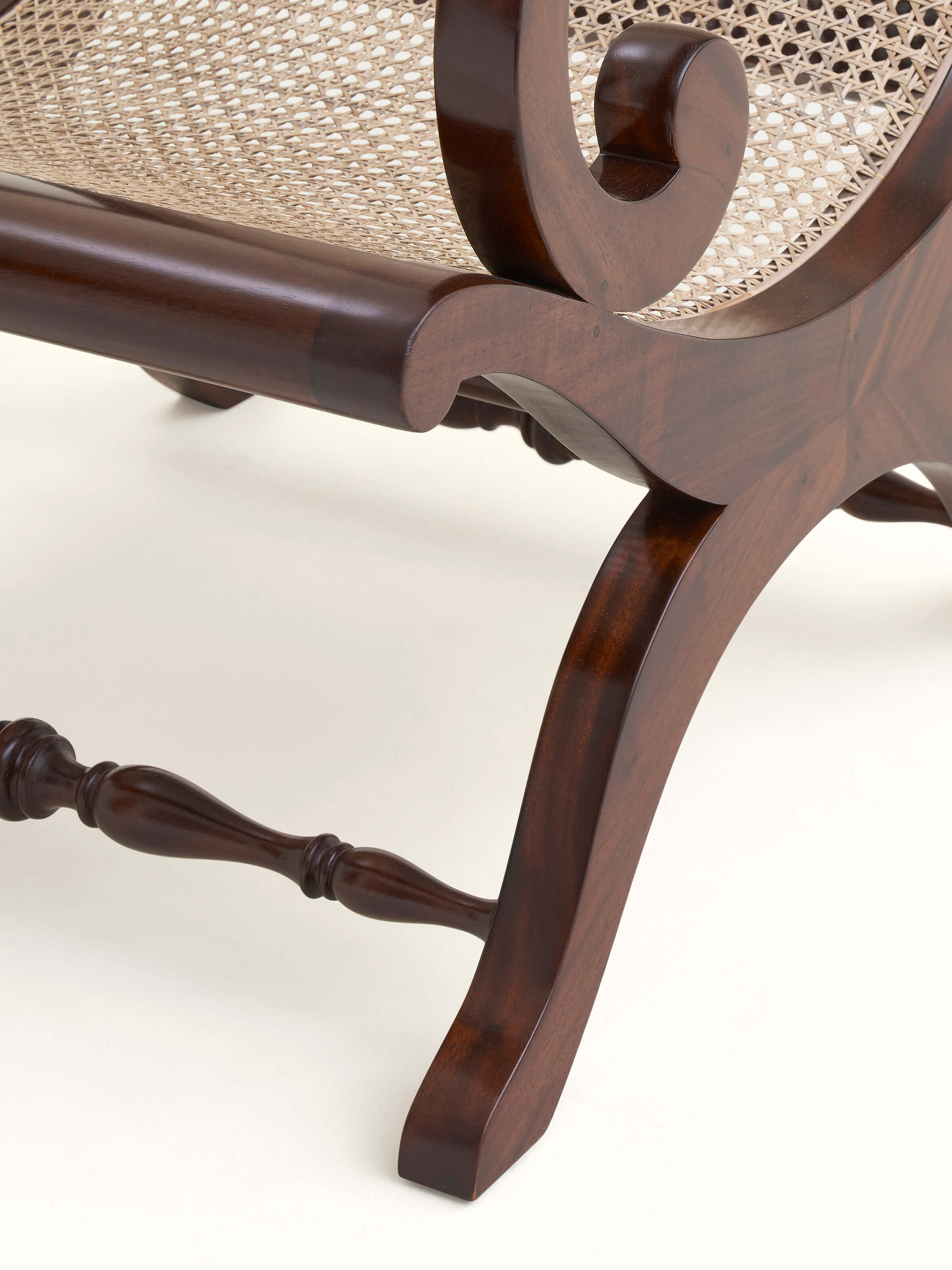 Close-up of Mahogany wood & cane wing chair, highlighting the rich wood texture and detailed cane design