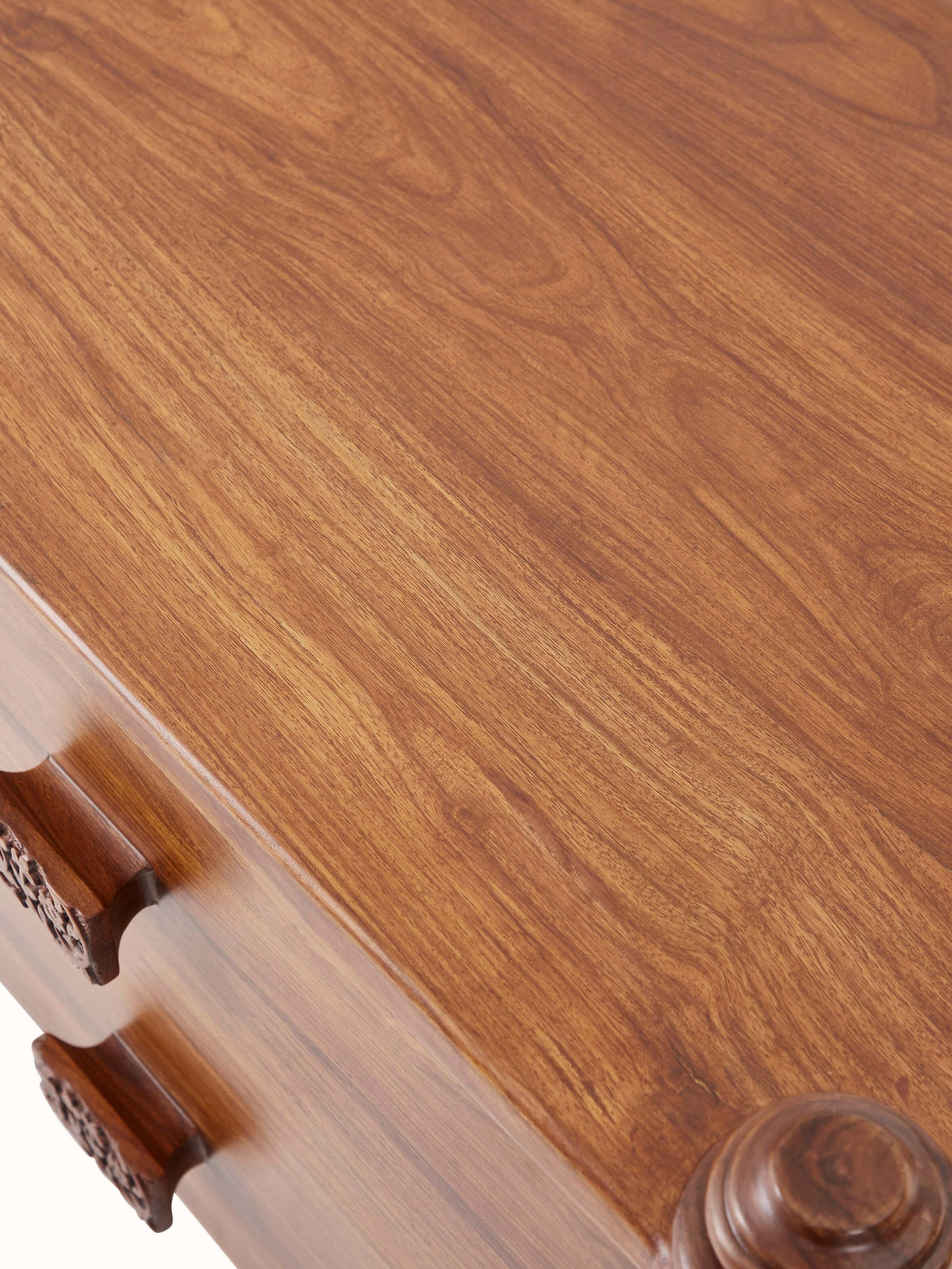 Detailed side view of Carved Sheesham Wood Bedside Table highlighting intricate carvings and wood grain.