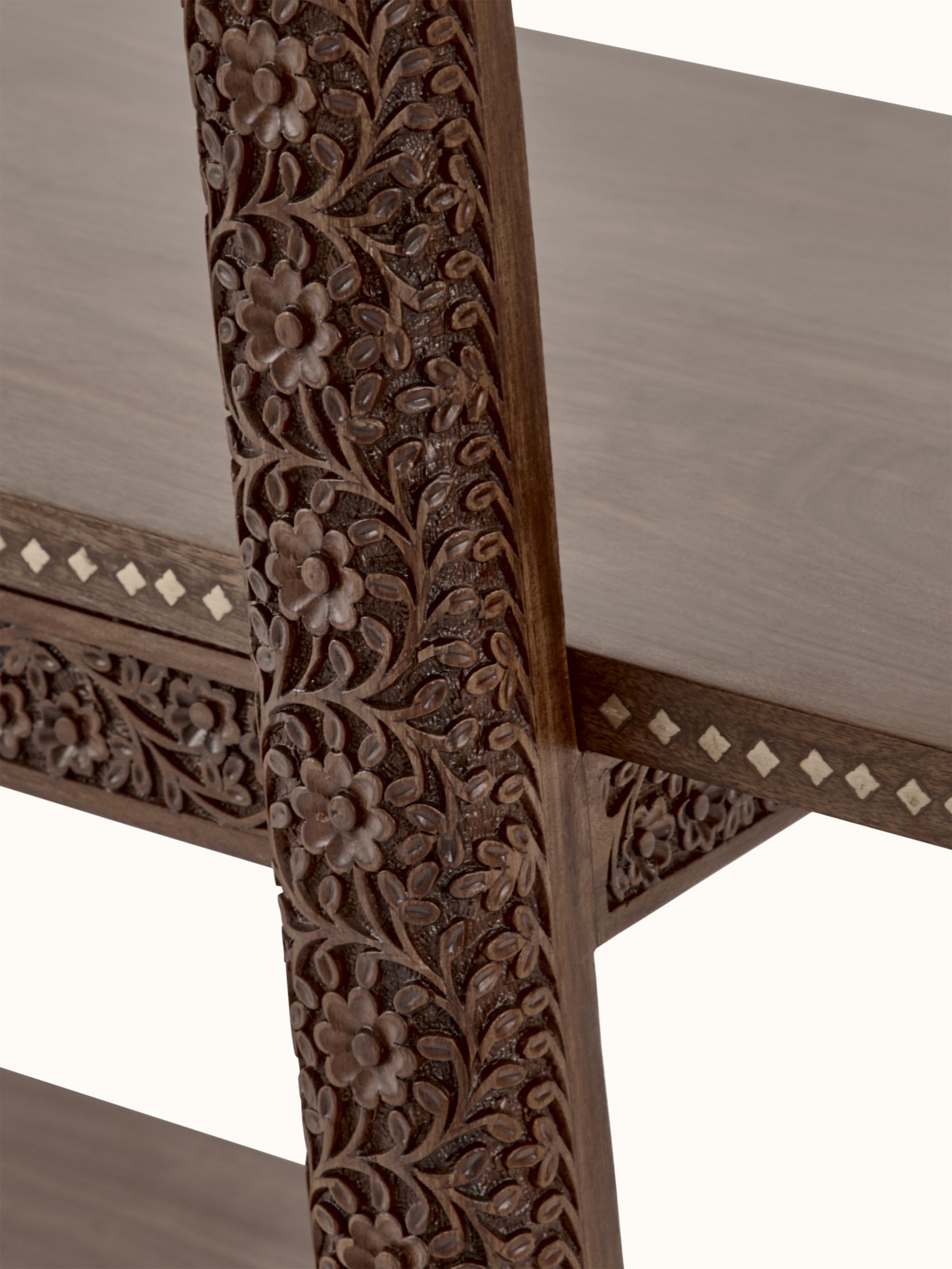 Close-up of carvings on sheesham wood bookshelf, emphasizing intricate woodwork details