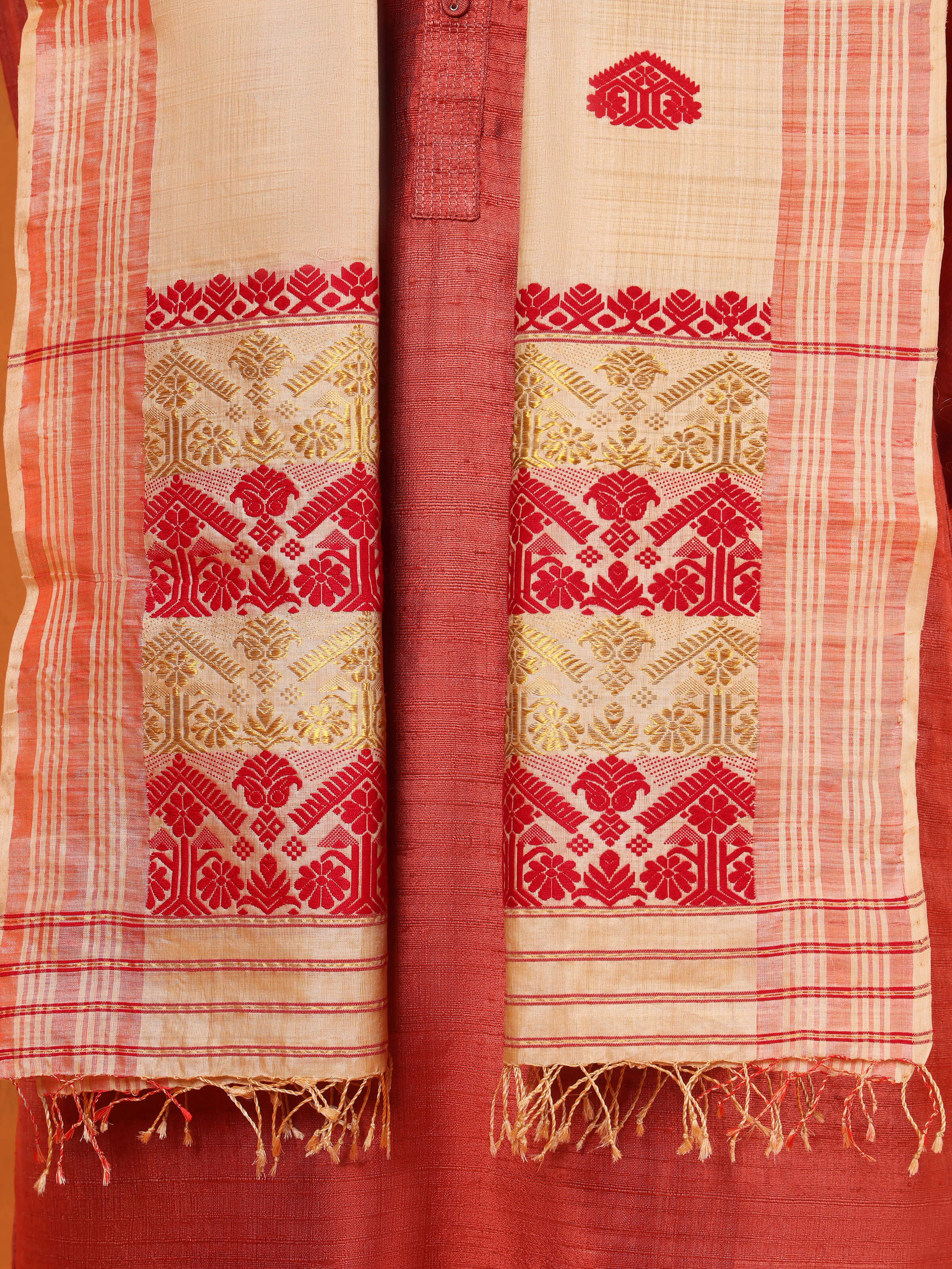 Detail shot of peach tussar silk stole focusing on subtle weave and border
