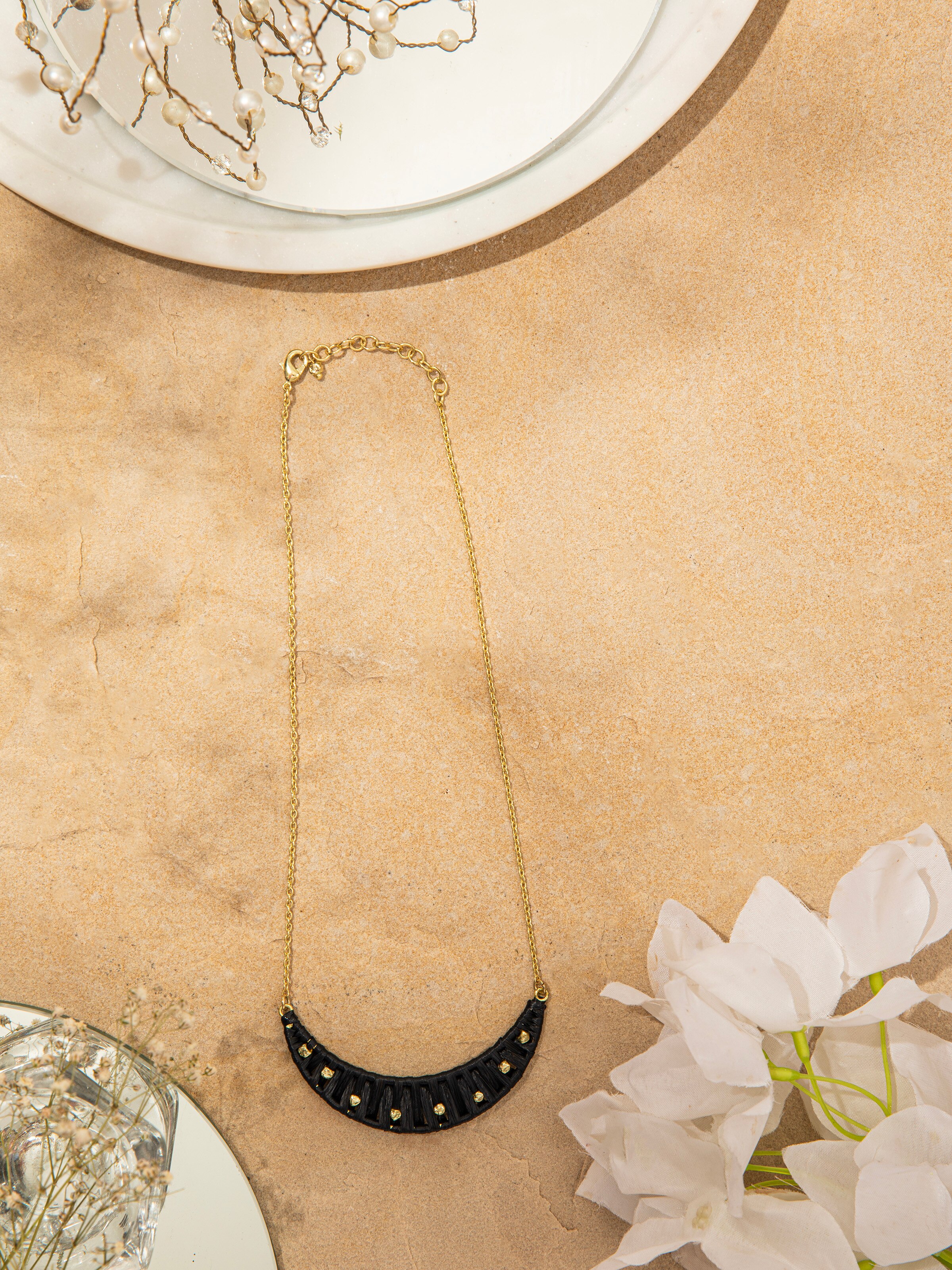 Close-up of raffia fibre long necklace focusing on the texture and detailed craftsmanship of the natural fibres.