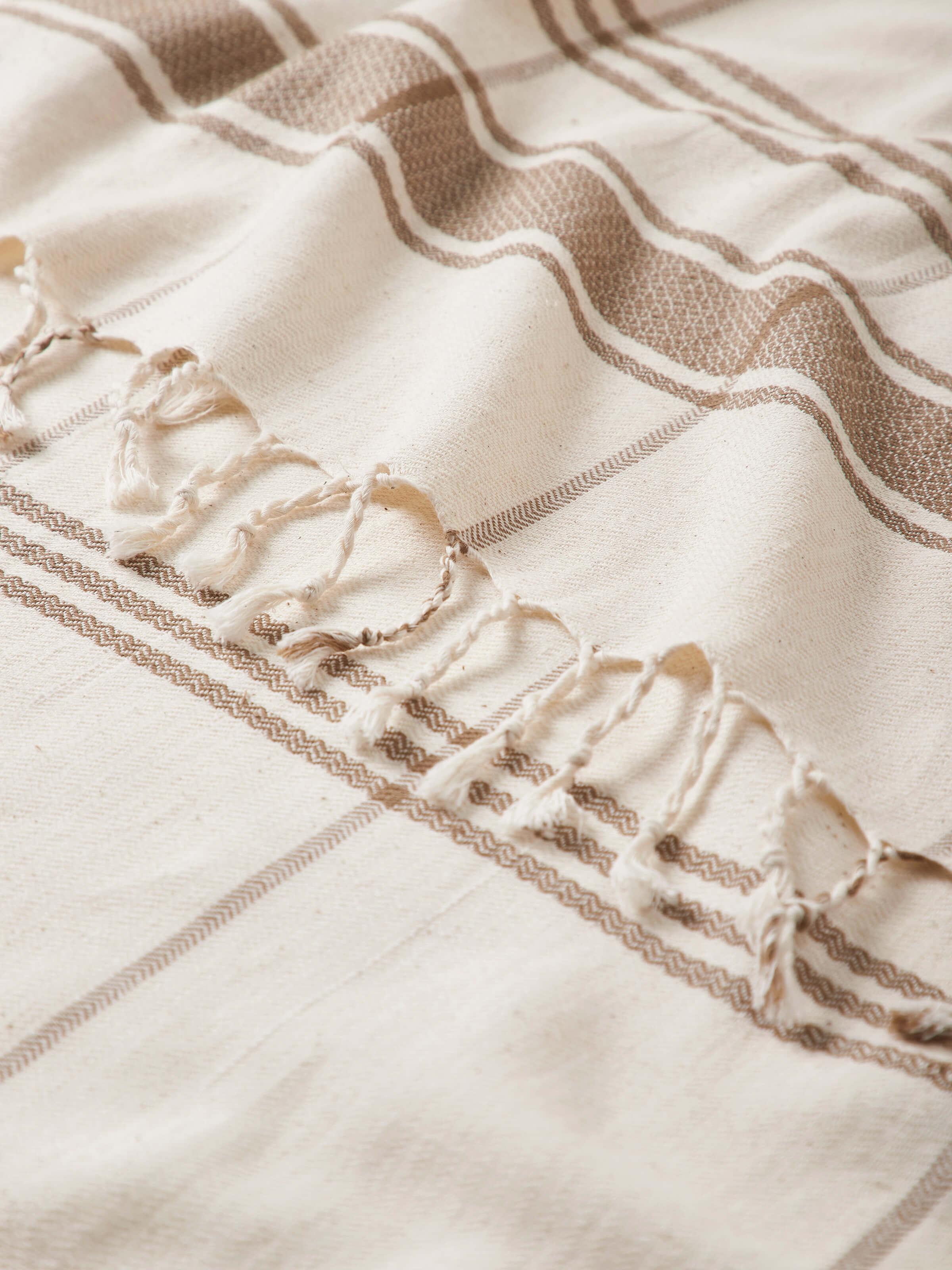 Side view of Sarvika Brown Checks Cotton Bath Towel (M) draped over a surface, showcasing the towel’s design and fabric quality.