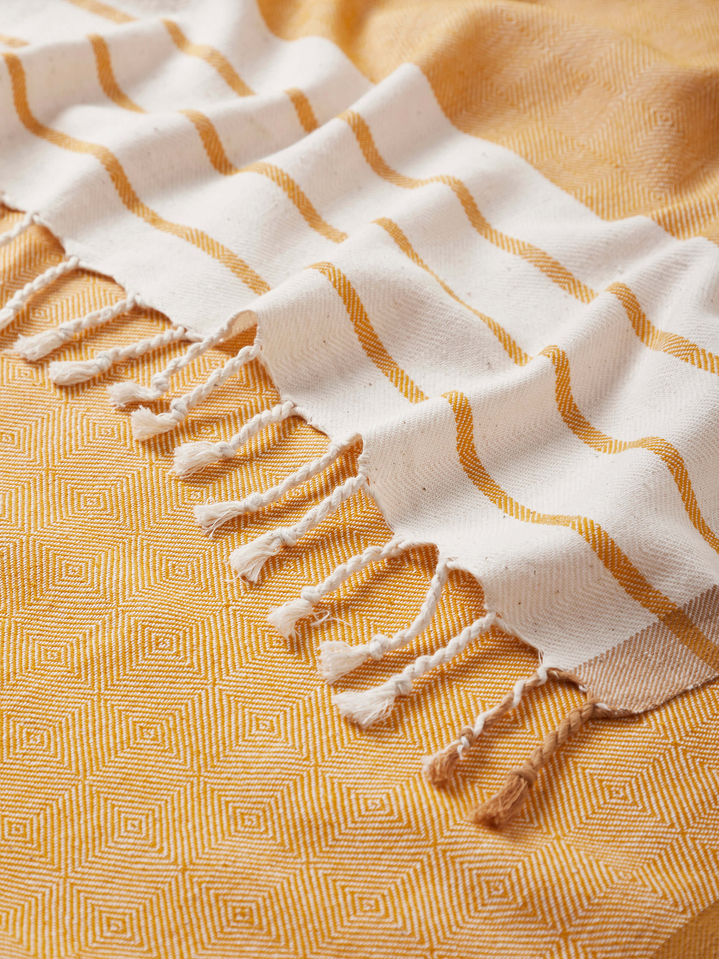 Samitha yellow stripe cotton textured bath towel (M), showing the towel in use to demonstrate its size and texture.