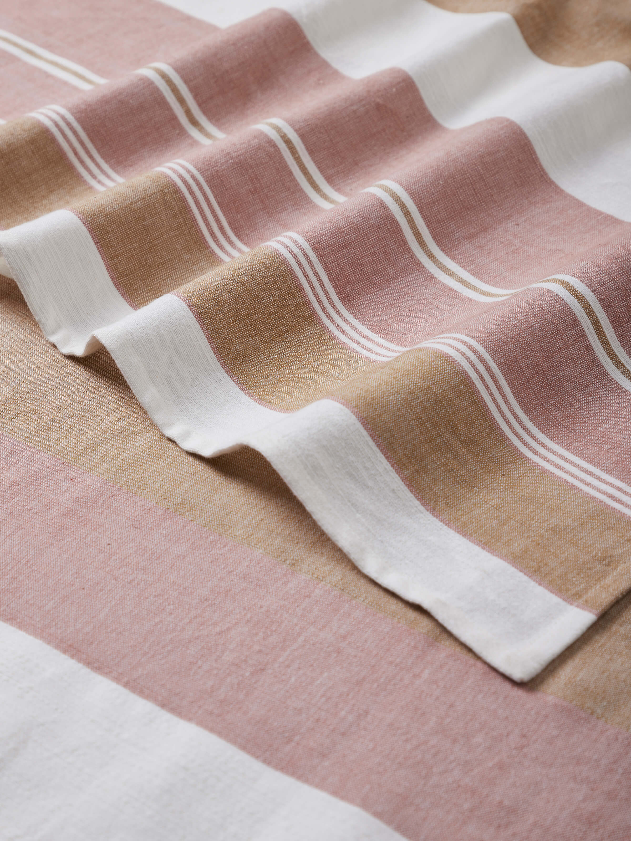 Large maroon cotton bath towel displayed in a flat lay, emphasizing its soft texture and stylish striped detailing.