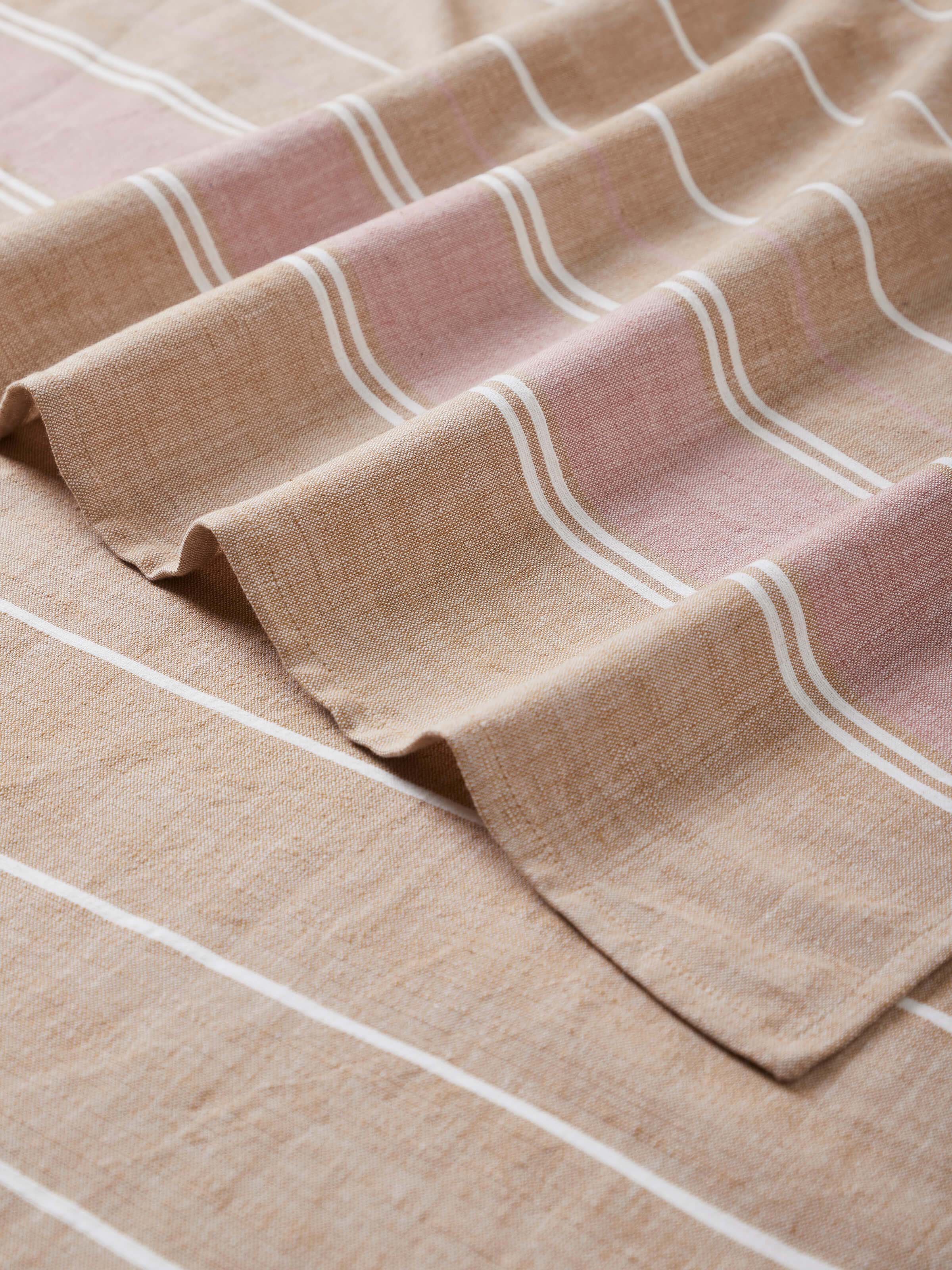 Angled view of Samistha brown stripe cotton striped bath towel (L) showing its full length and design