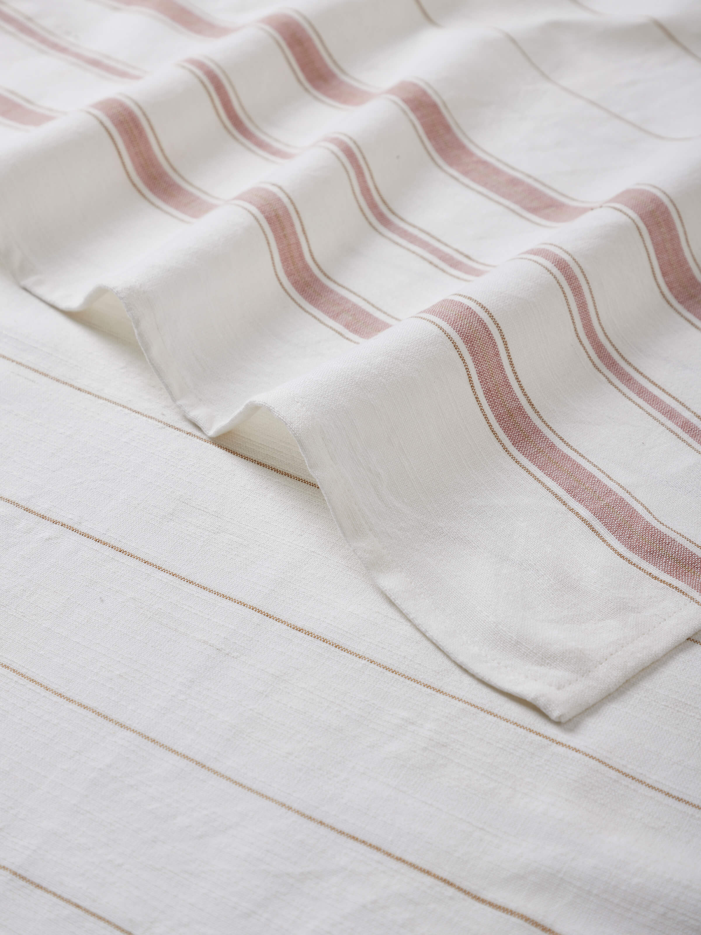 Adrita white stripe cotton bath towel (M) displayed folded, highlighting its absorbent cotton fabric and striped design.