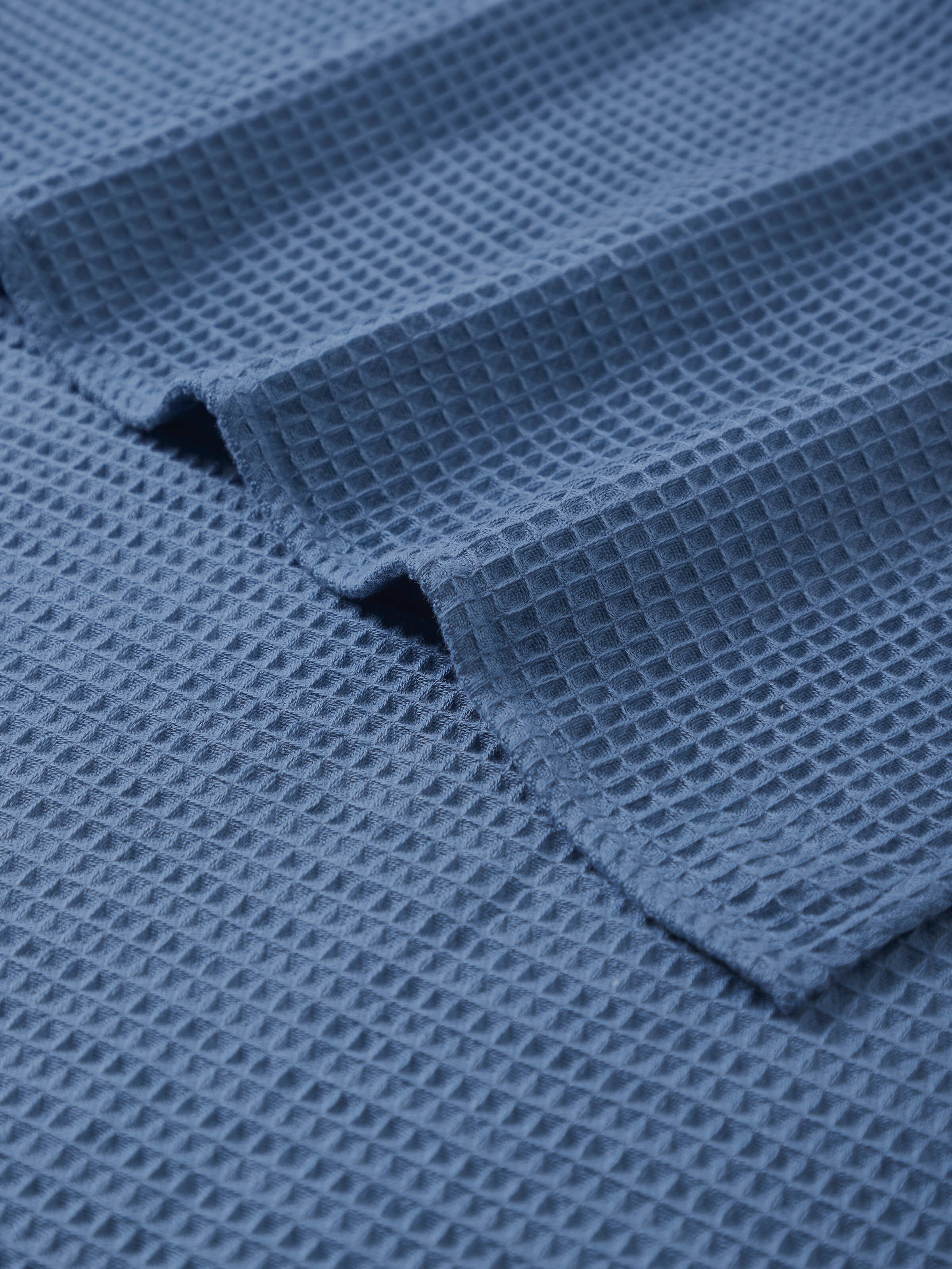 Detailed view of Amala Waffle Blue Solid Cotton Bath Towel highlighting the fabric and color.