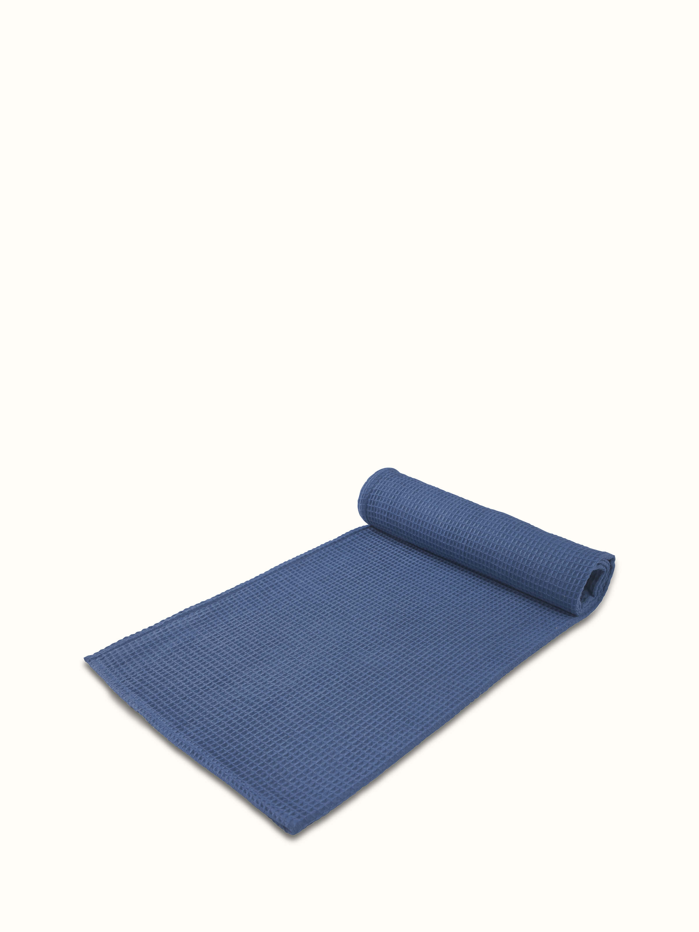 Angled view of Amala Waffle Blue Solid Cotton Bath Towel showing the waffle pattern and texture.