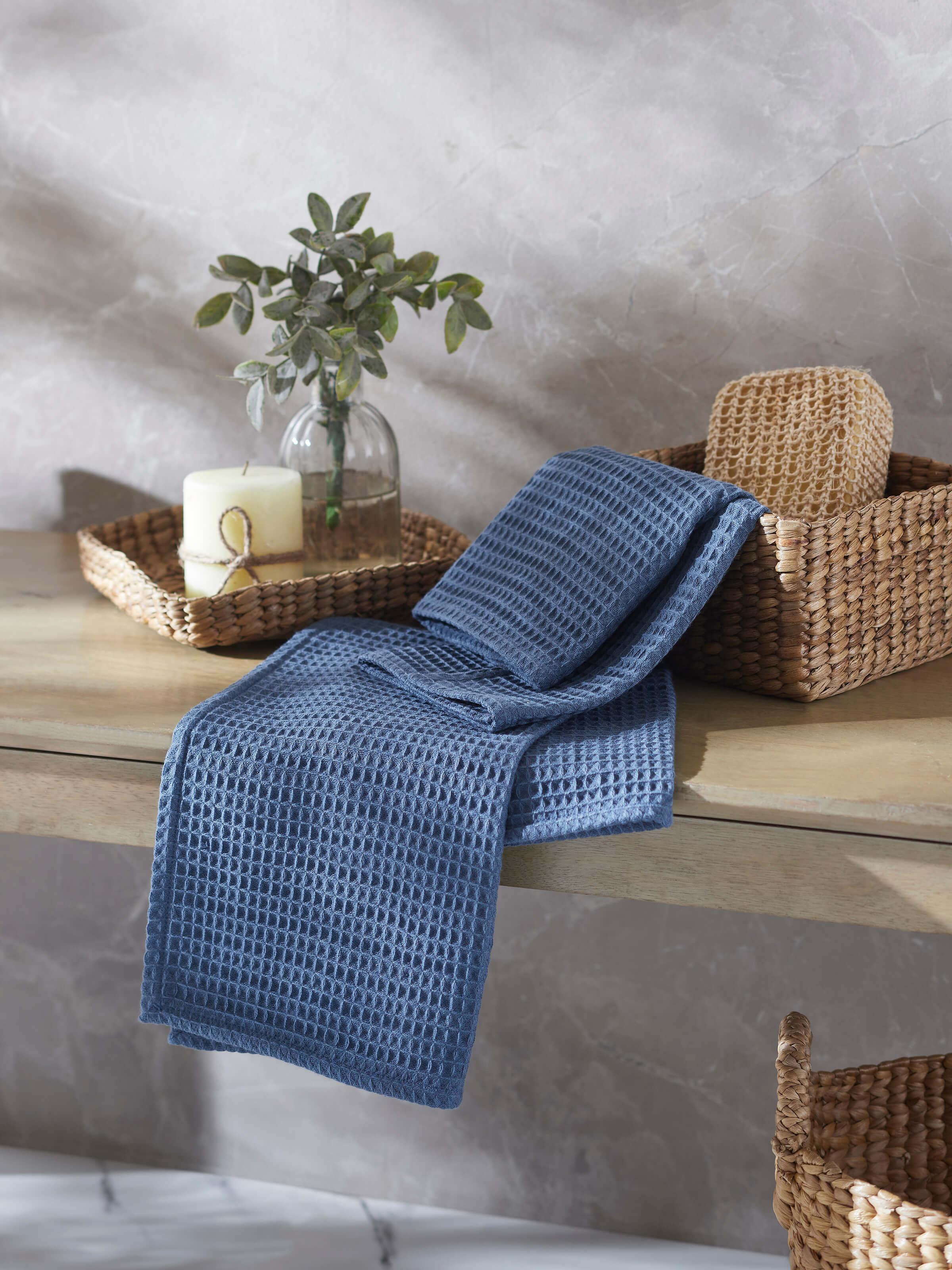 Close-up of Amala blue solid cotton hand towels, focusing on the waffle texture and the vibrant blue hue.