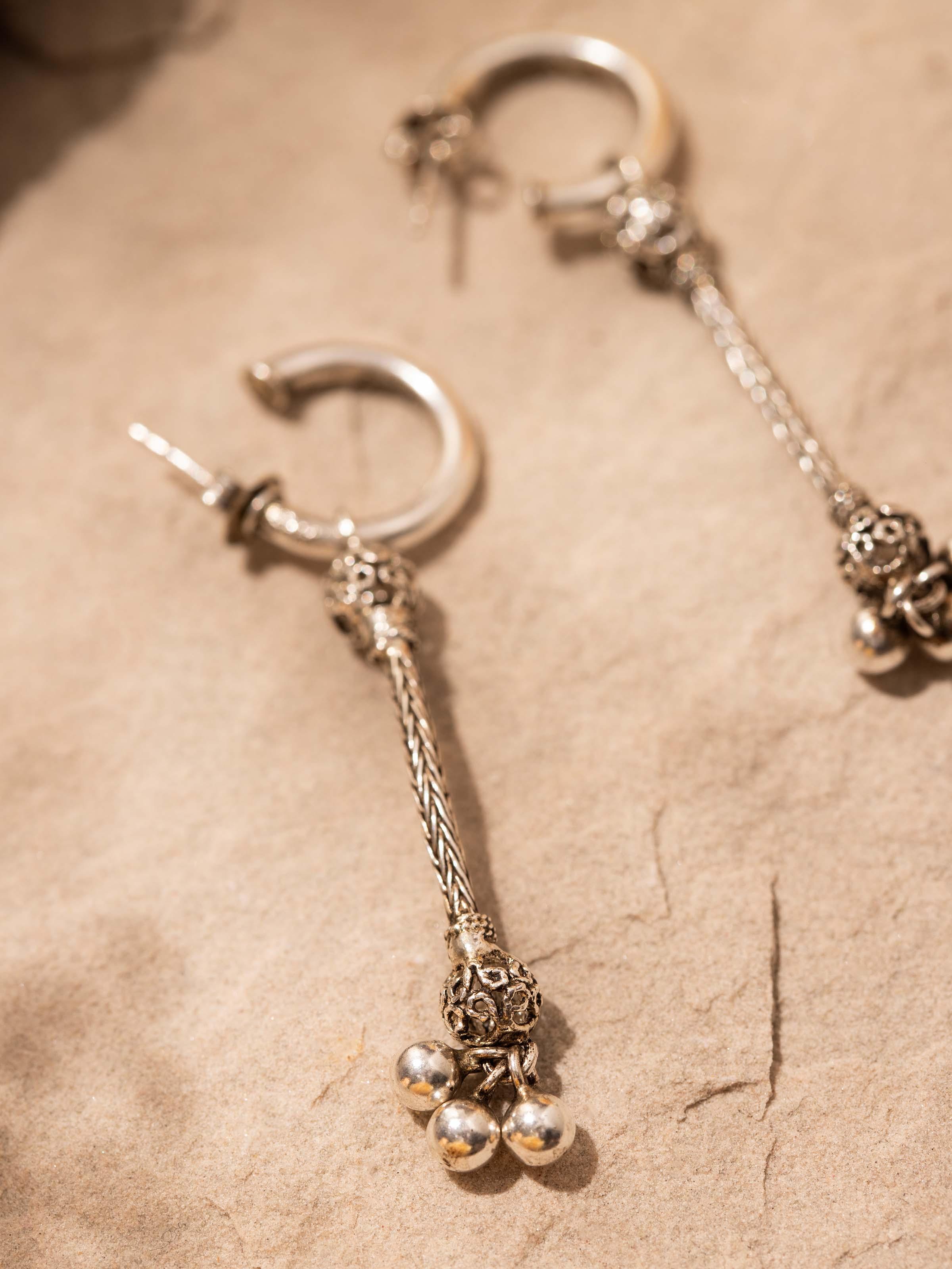 Angled view of Silver Drop Earrings emphasizing the earring's elegant design and reflective surface
