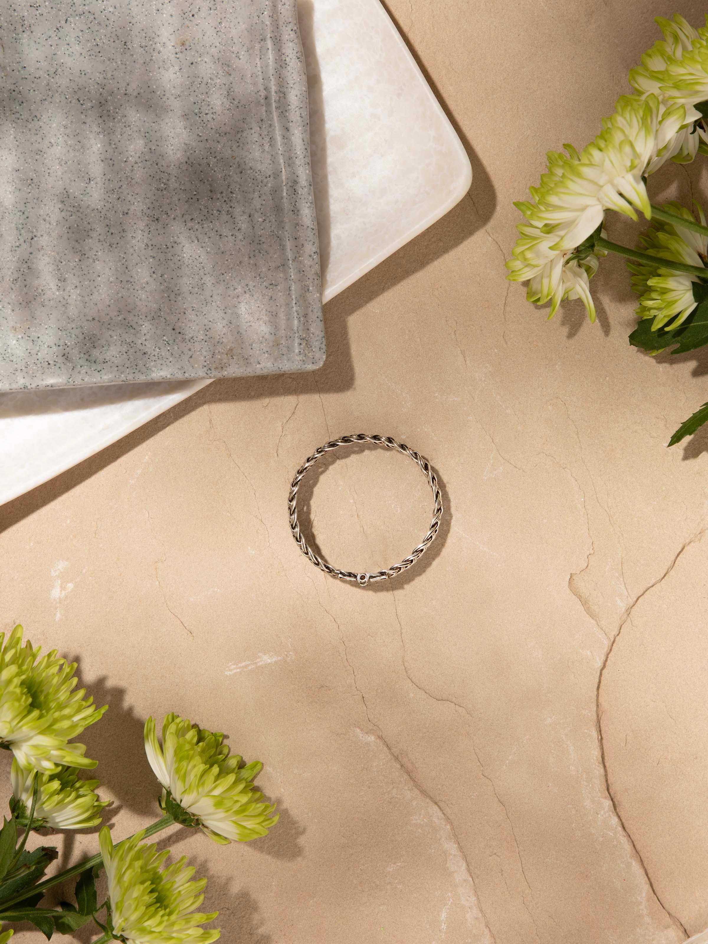 Silver bangle worn on wrist to display its elegant design and fit.