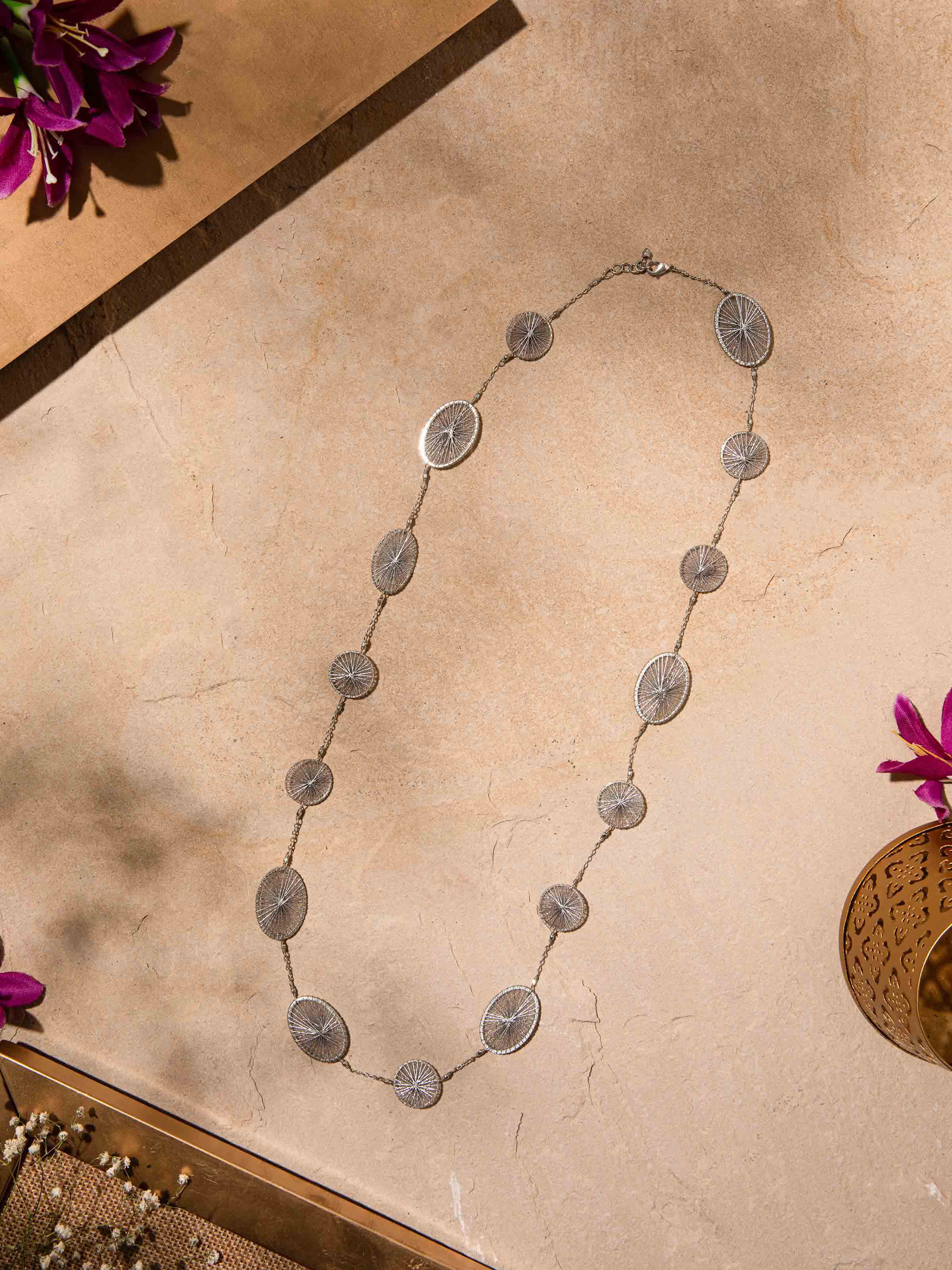 Close-up view of String Craft Long Necklace showing the intricate string patterns and vibrant colors.