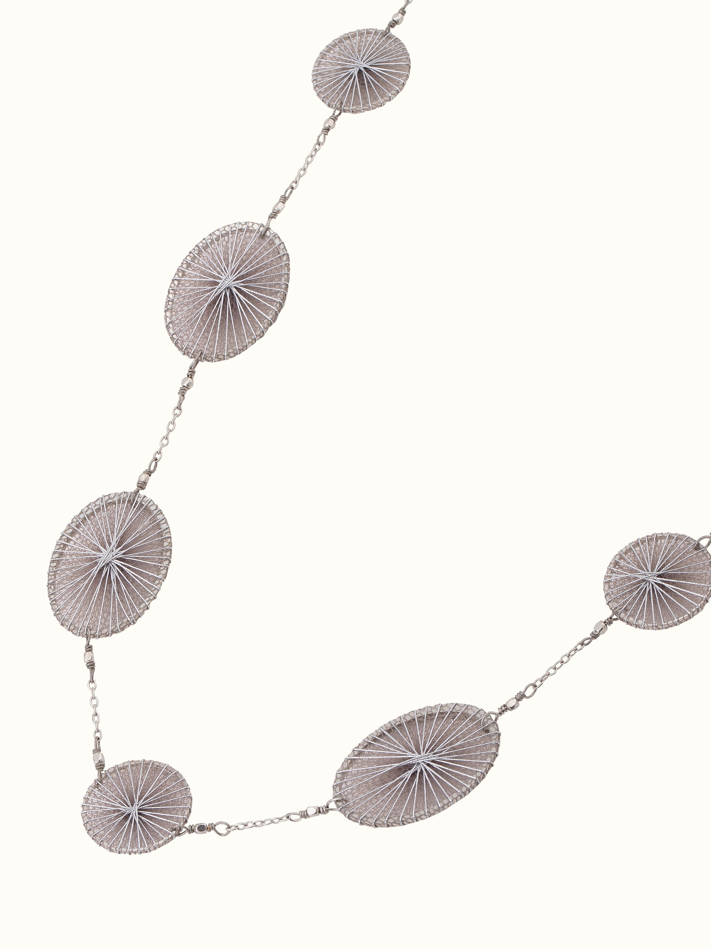 Overhead view of String Craft Long Necklace featuring colorful strings and elegant design.