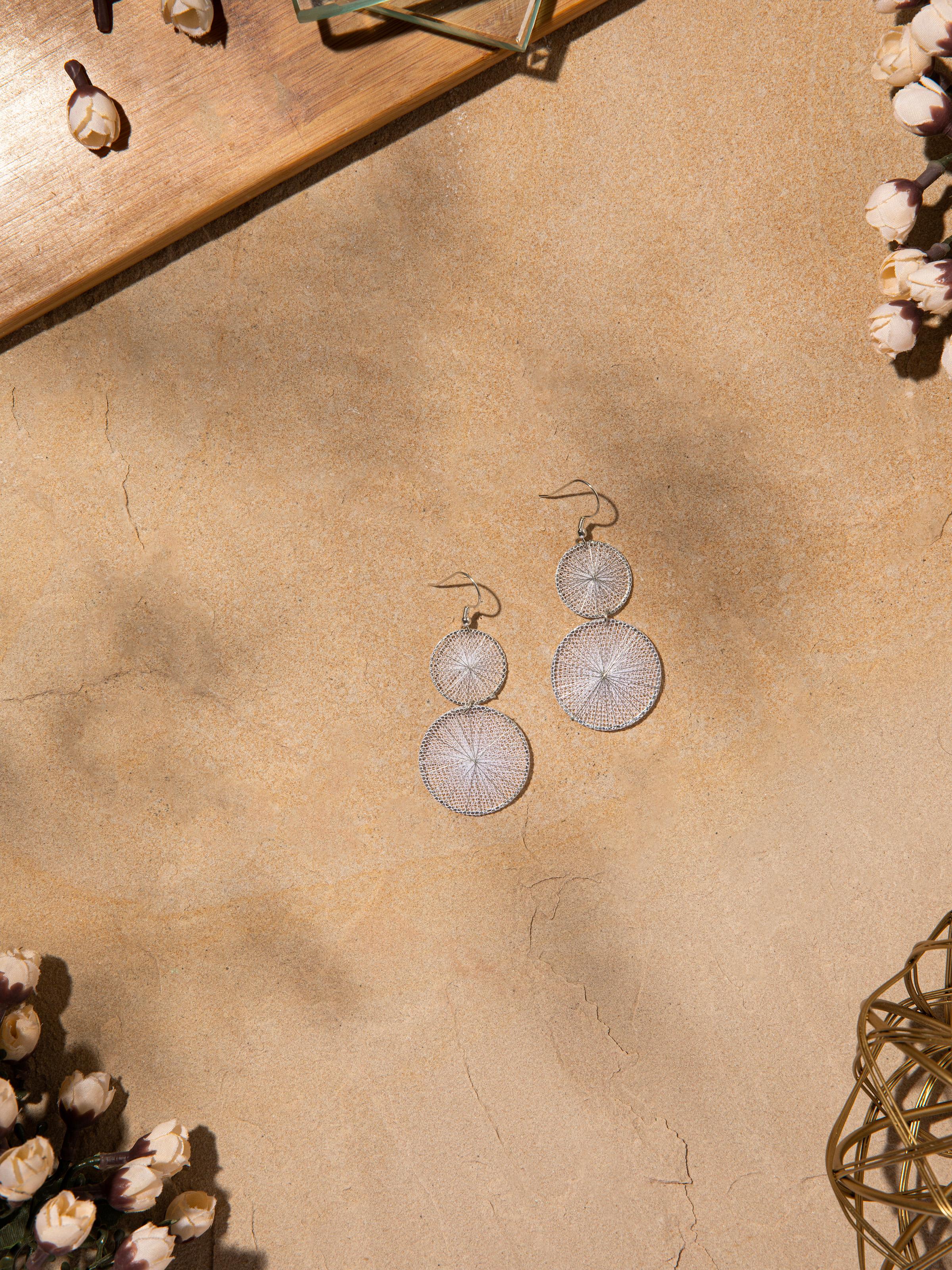 Angled view of String Craft Drop Earrings showcasing intricate detailing and unique design.
