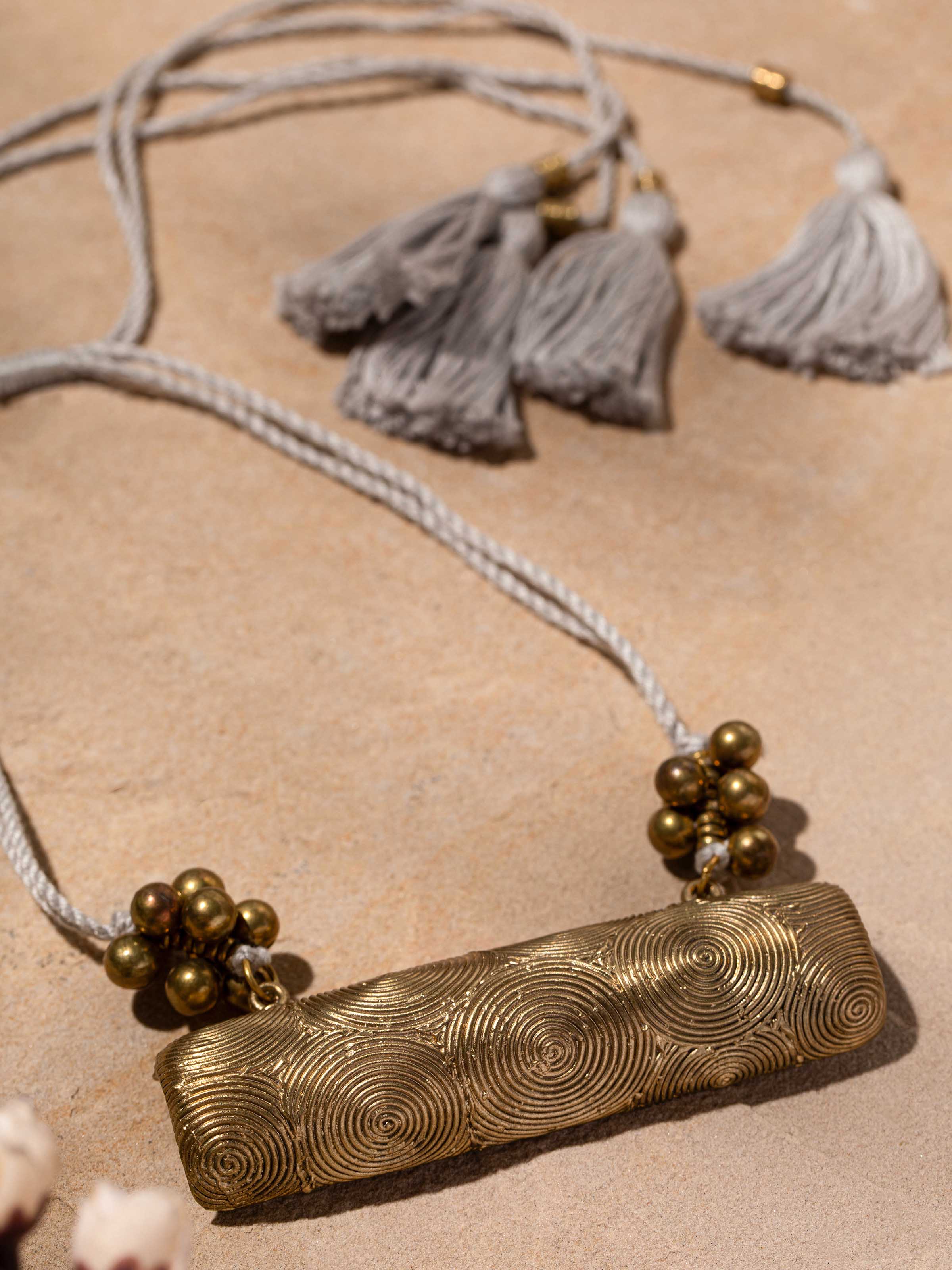 Detailed shot of Dhokra long necklace focusing on the unique tribal patterns.