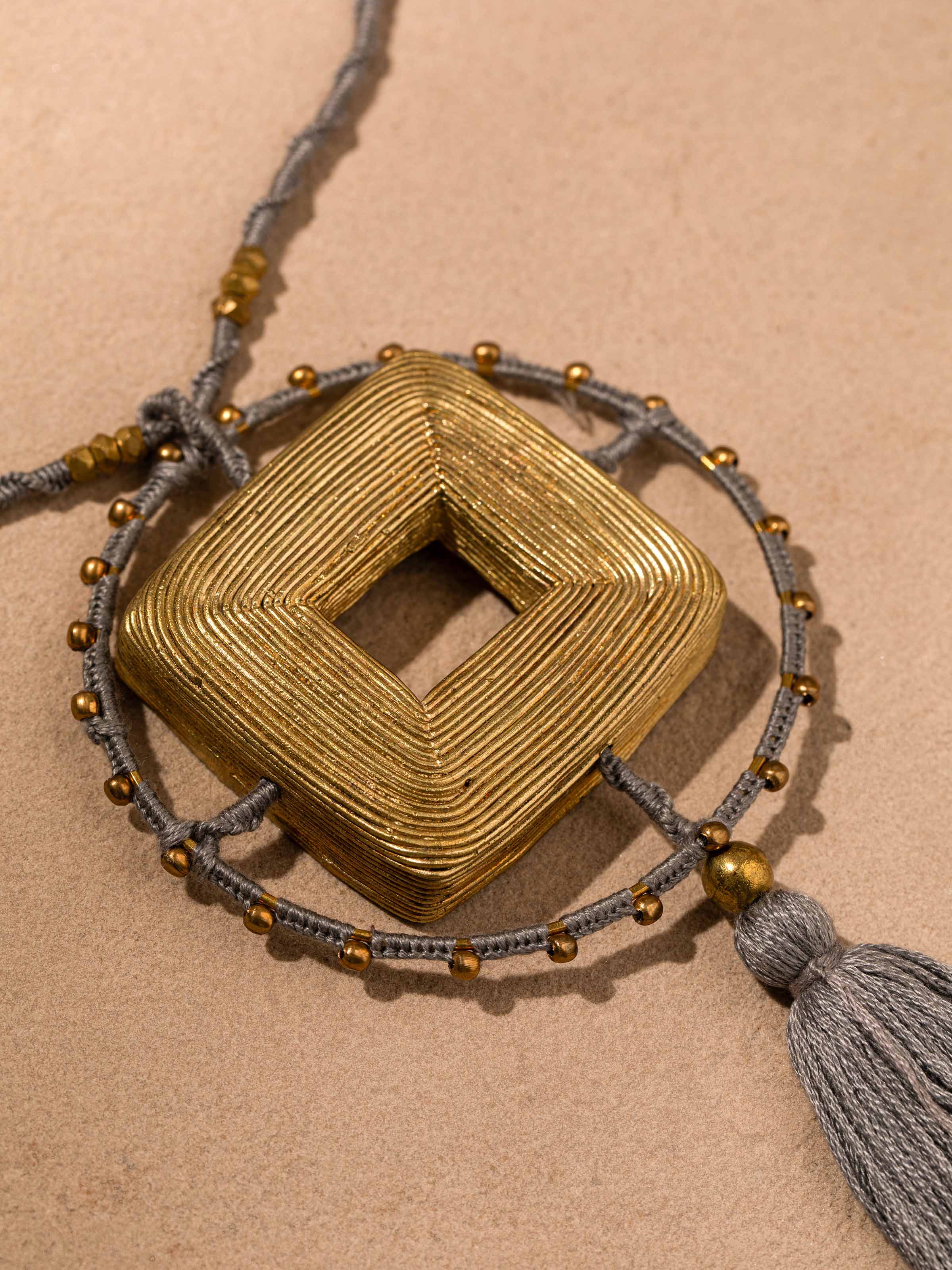 Detailed view of Dhokra Pendant & Chain emphasizing traditional design and intricate metalwork.