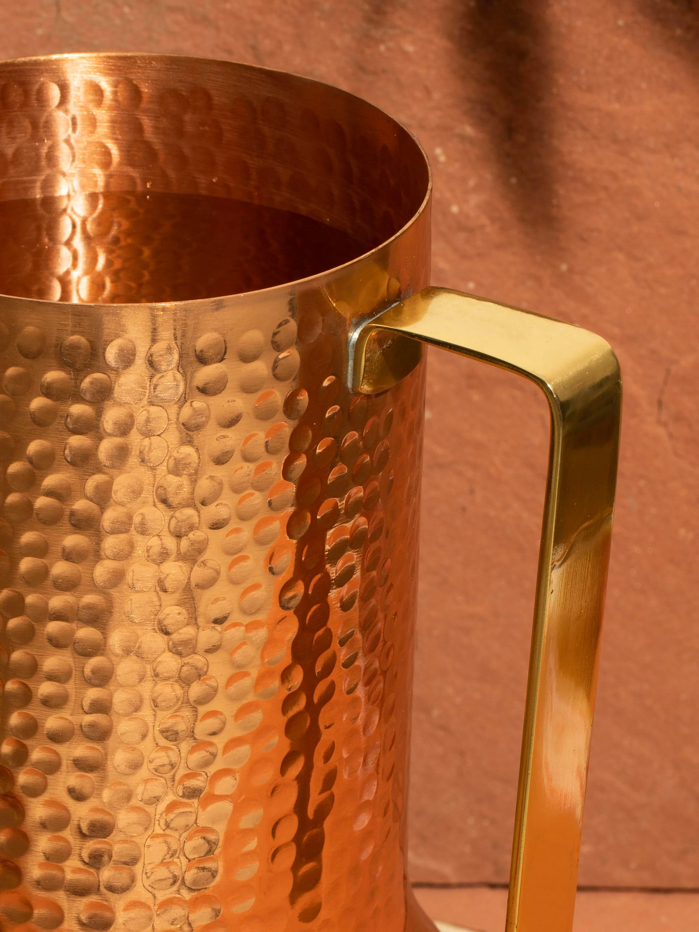 Side view of Copper Metal Jug highlighting its cylindrical shape and hammered texture.