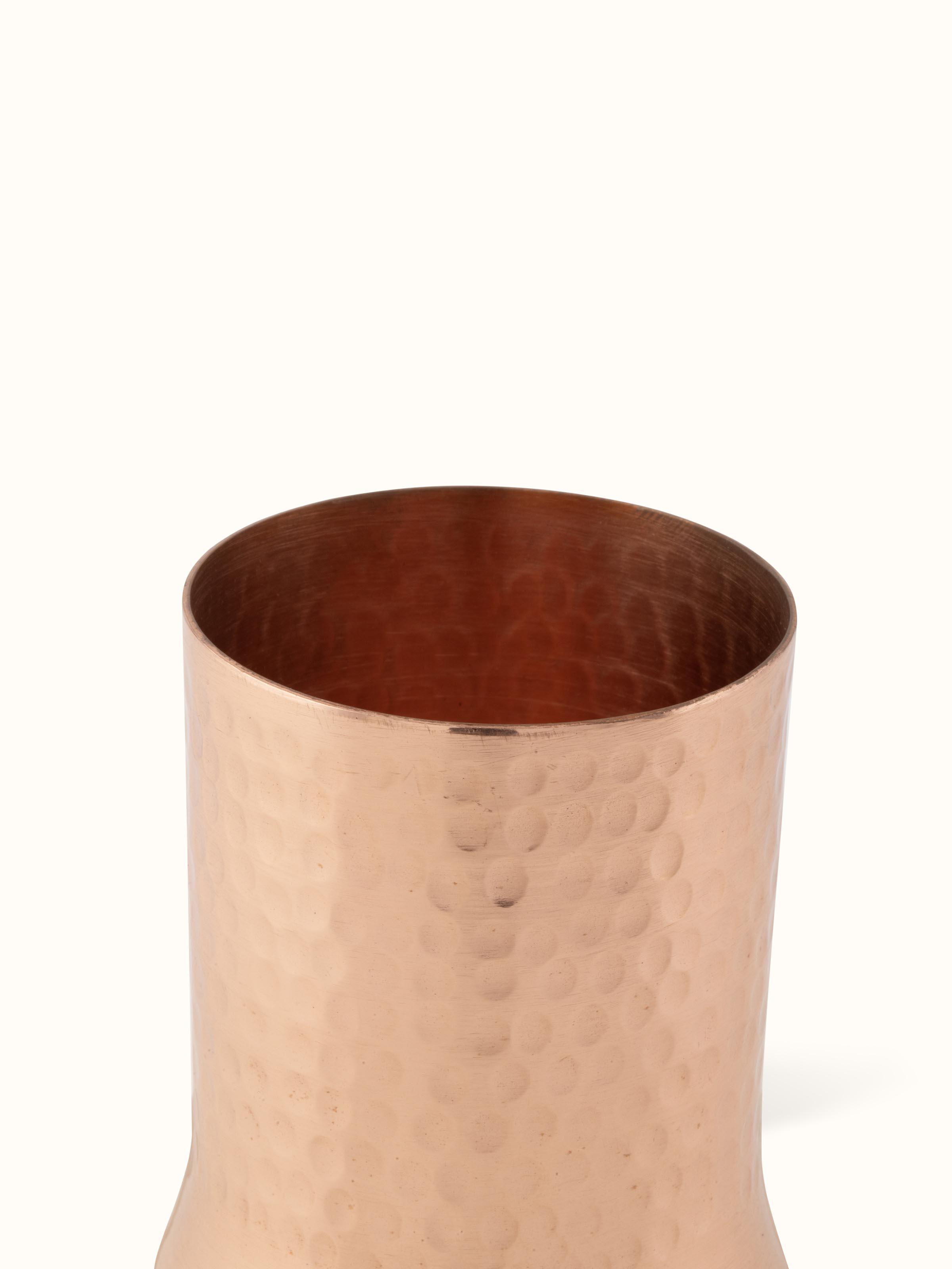 Detailed view of the base of copper metal glass, showcasing its sturdy build and polished finish.