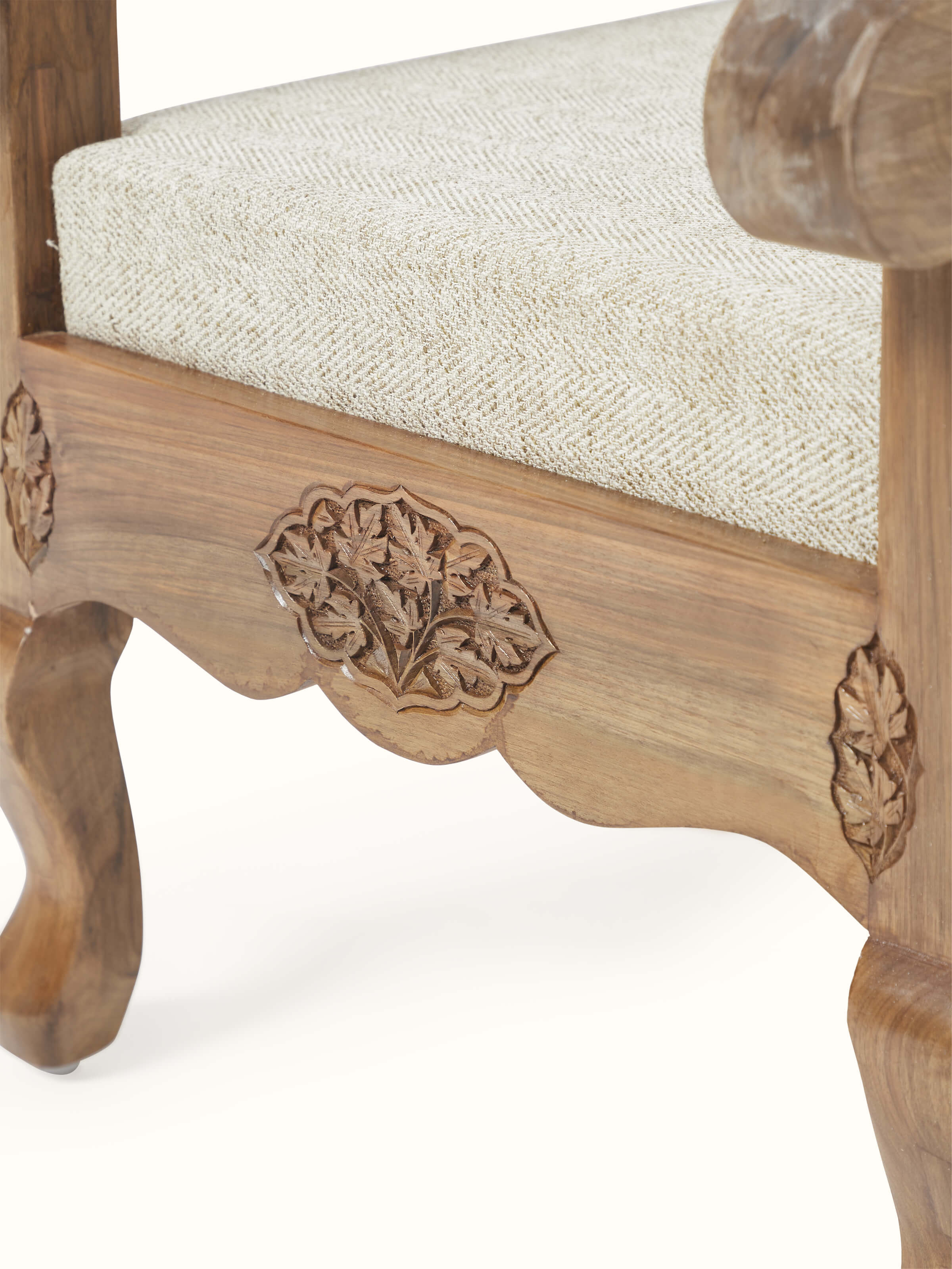 Detailed view of the carved walnut wood frame and handloom fabric upholstery of the armchair, emphasizing intricate woodwork and texture