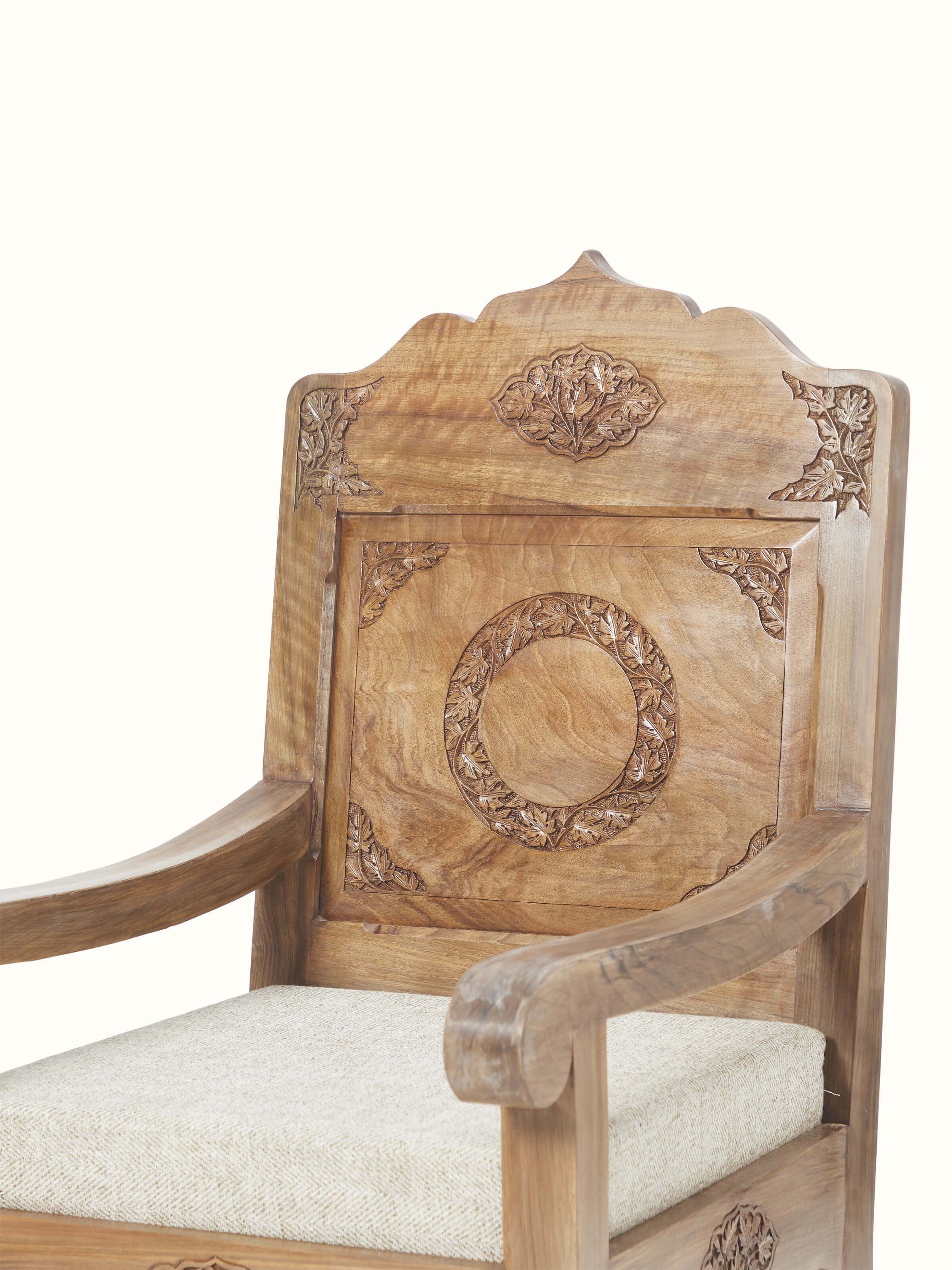 Close-up of the handloom fabric and walnut wood carving details on the armchair, highlighting the quality of materials and design