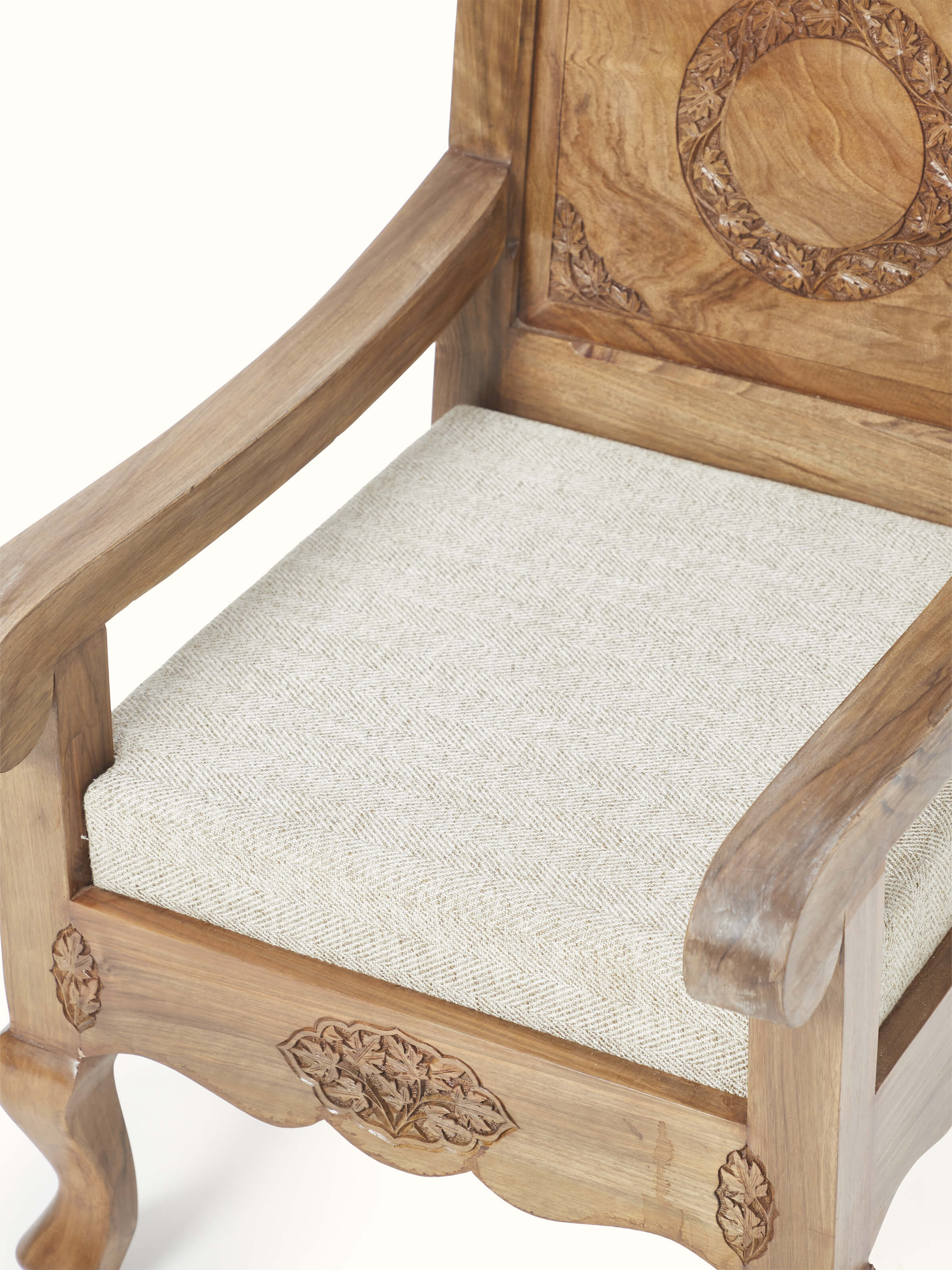 View of the armrest and upholstered fabric of the carved walnut wood armchair, focusing on the comfort and detailed craftsmanship