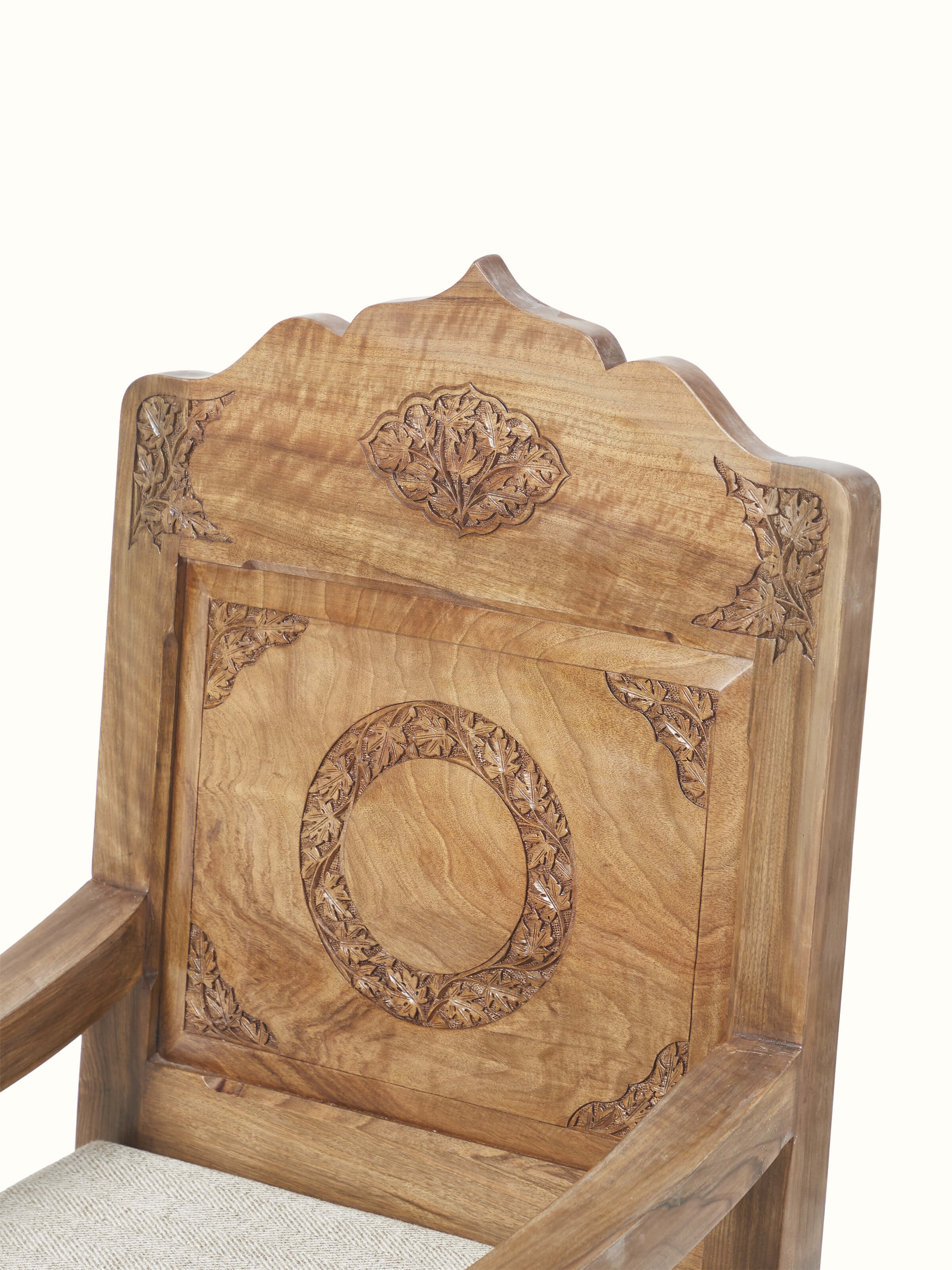 Artistic view of the handloom fabric upholstered carved walnut wood armchair, capturing its stylish and intricate design elements