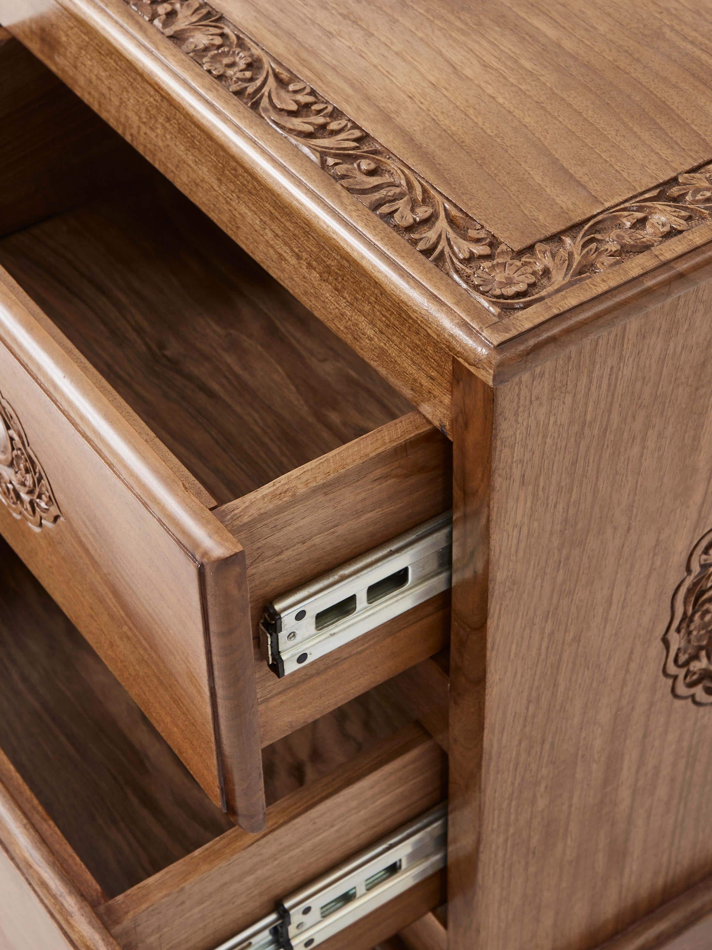 Close-up of the walnut wood texture and carvings on the bedside table, showcasing the quality and detail