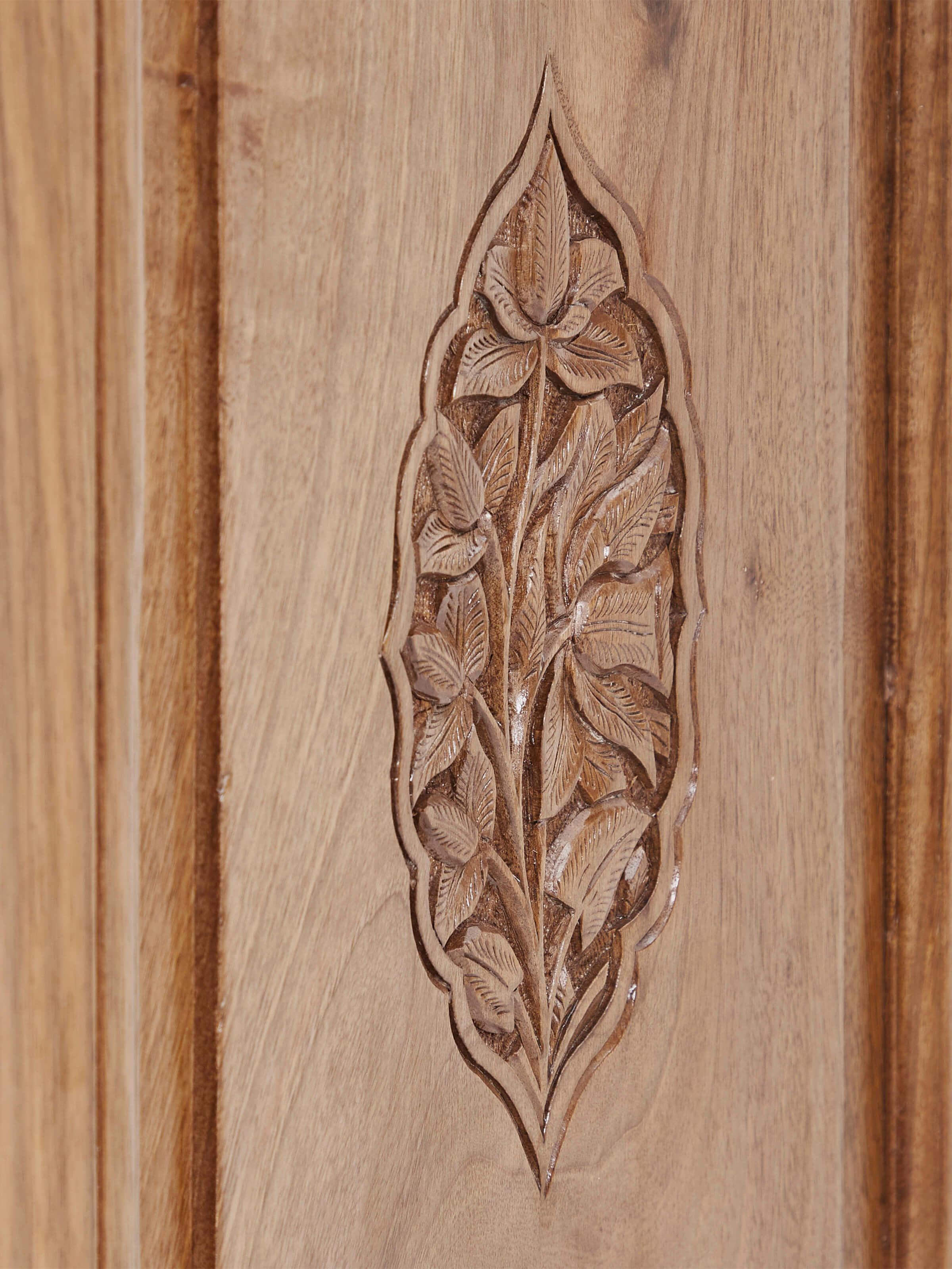 Close-up view of carved walnut drawer chest, showcasing detailed carving patterns