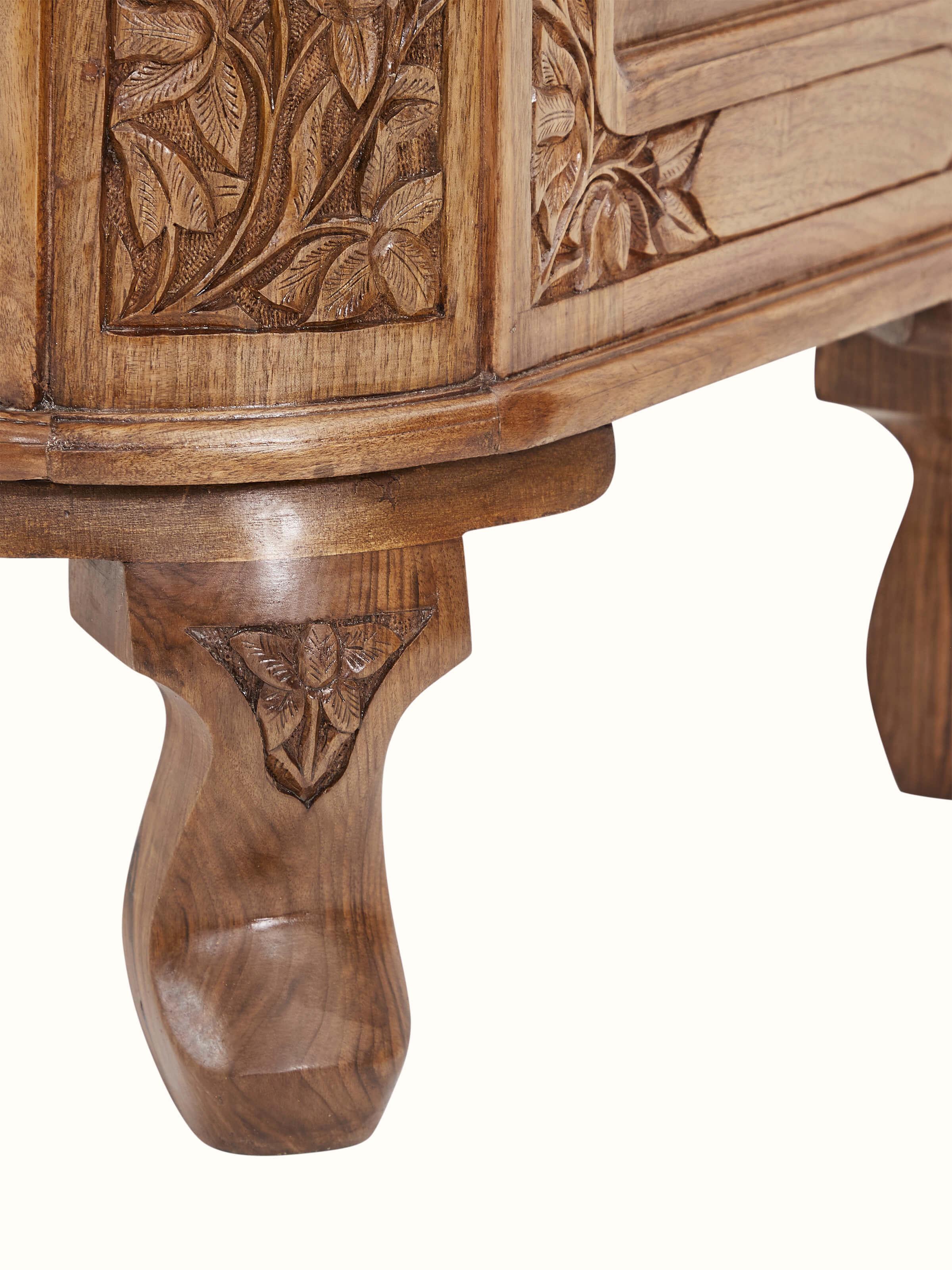 Close-up of carved walnut drawer chest leg, displaying the intricate carving work