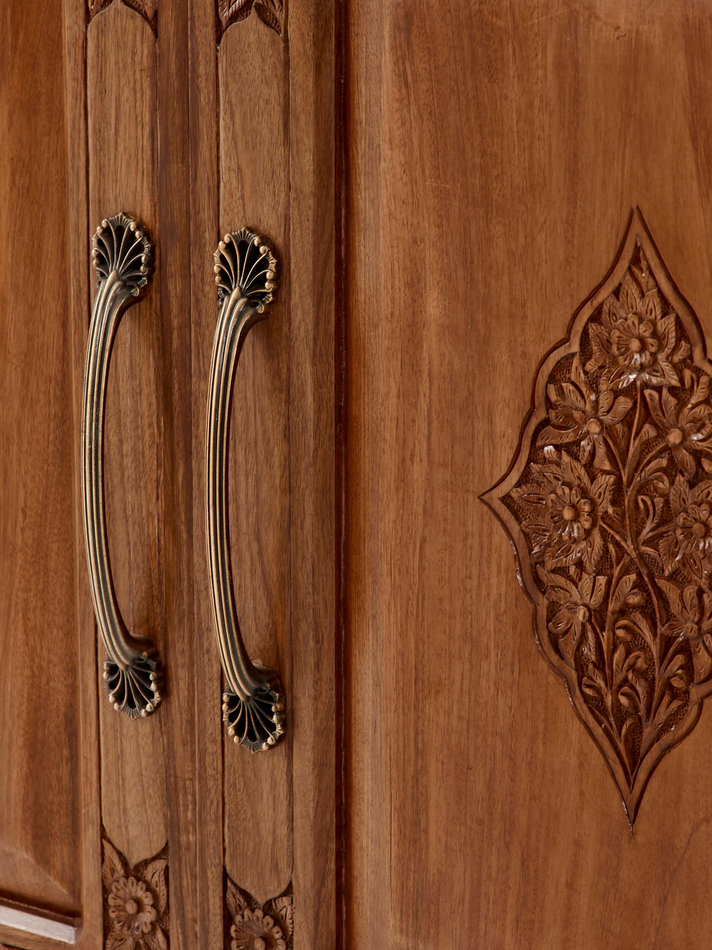 Detailed view of carved walnut wood wardrobe, highlighting the ornate carvings and wood texture