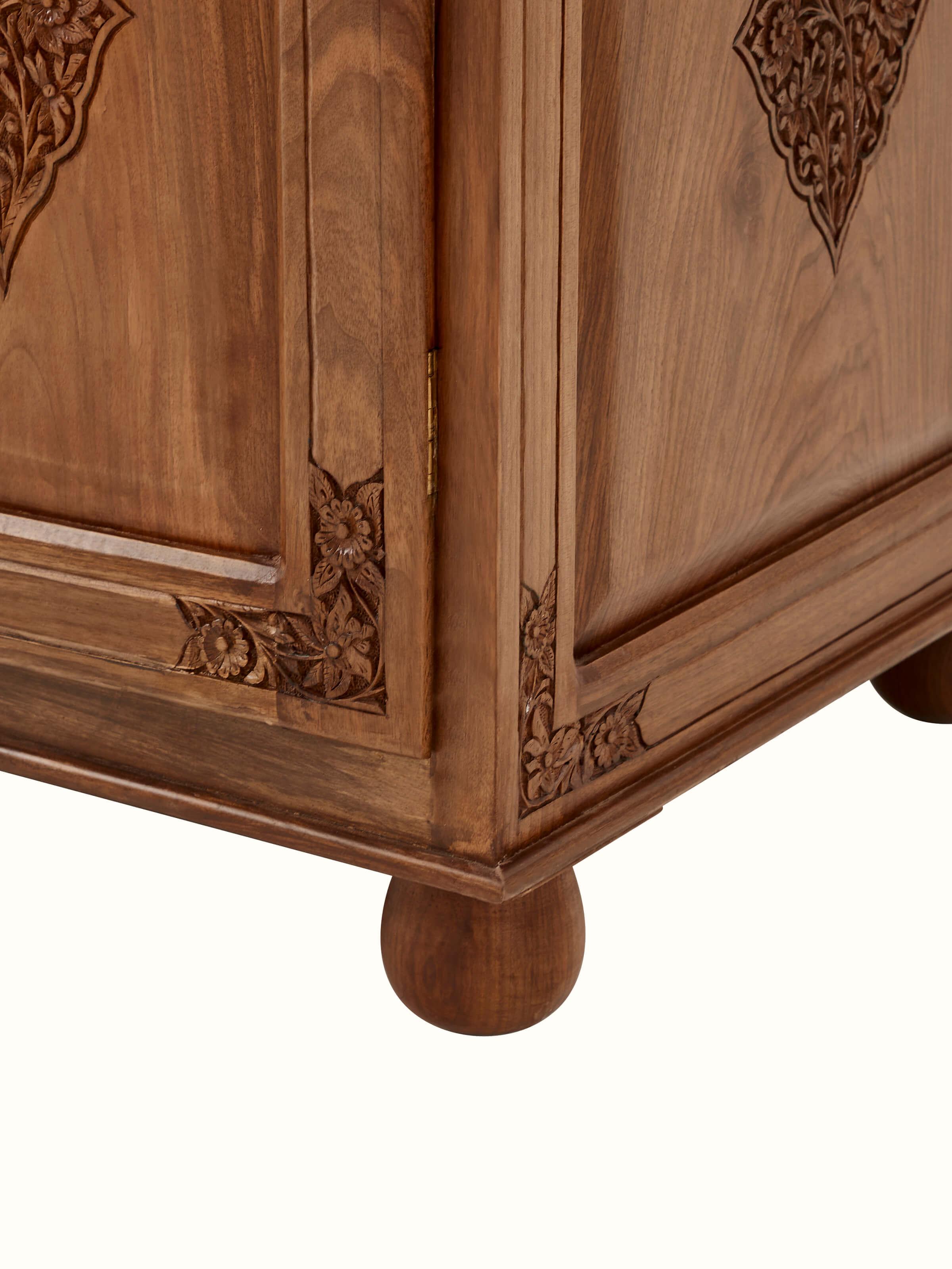 Close-up view of carved walnut wood wardrobe's carving details, showing the intricate patterns and craftsmanship