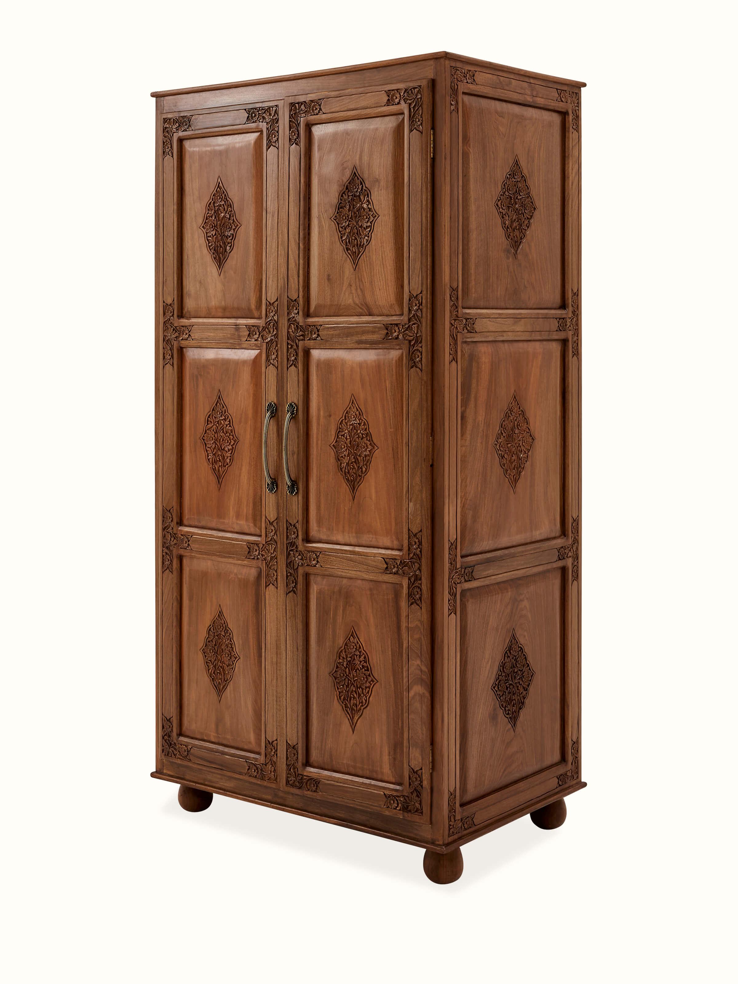 Detailed view of the carved walnut wood wardrobe, showing the ornate carvings and rich wood color