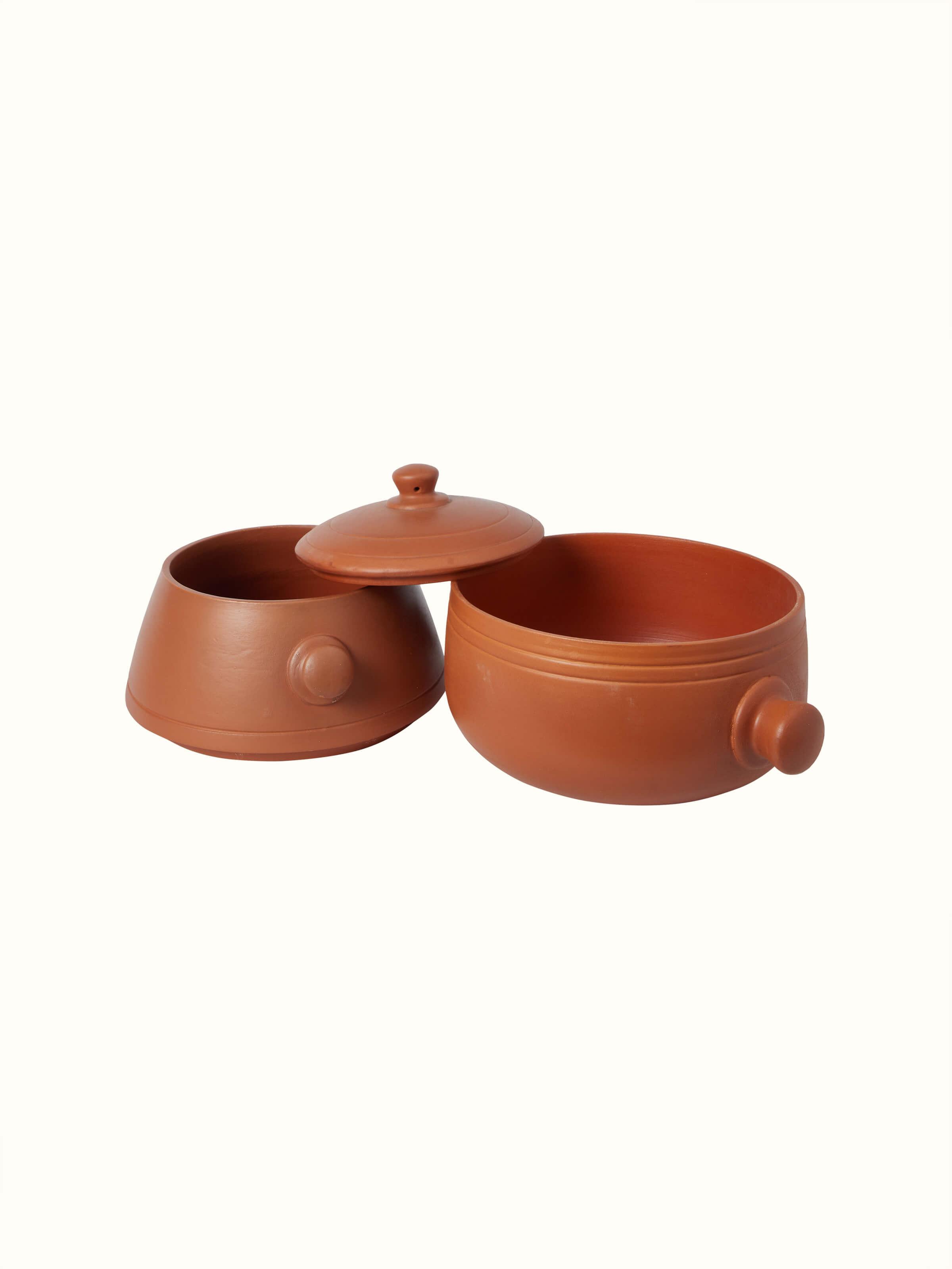 Angled view of tall terracotta clay cooking pot showing its detailed craftsmanship.
