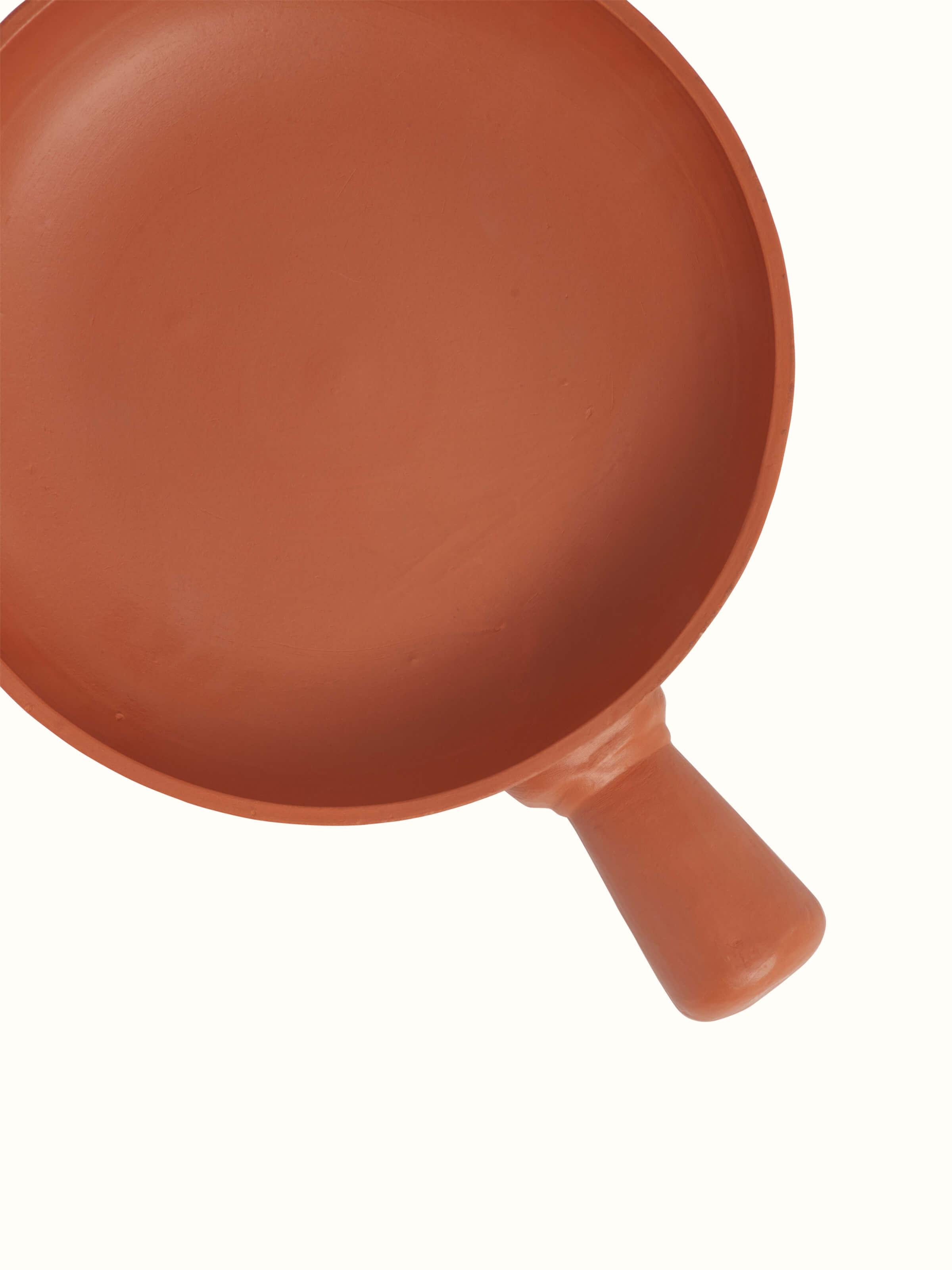 Side view of terracotta clay pan, showcasing its depth and natural clay texture.
