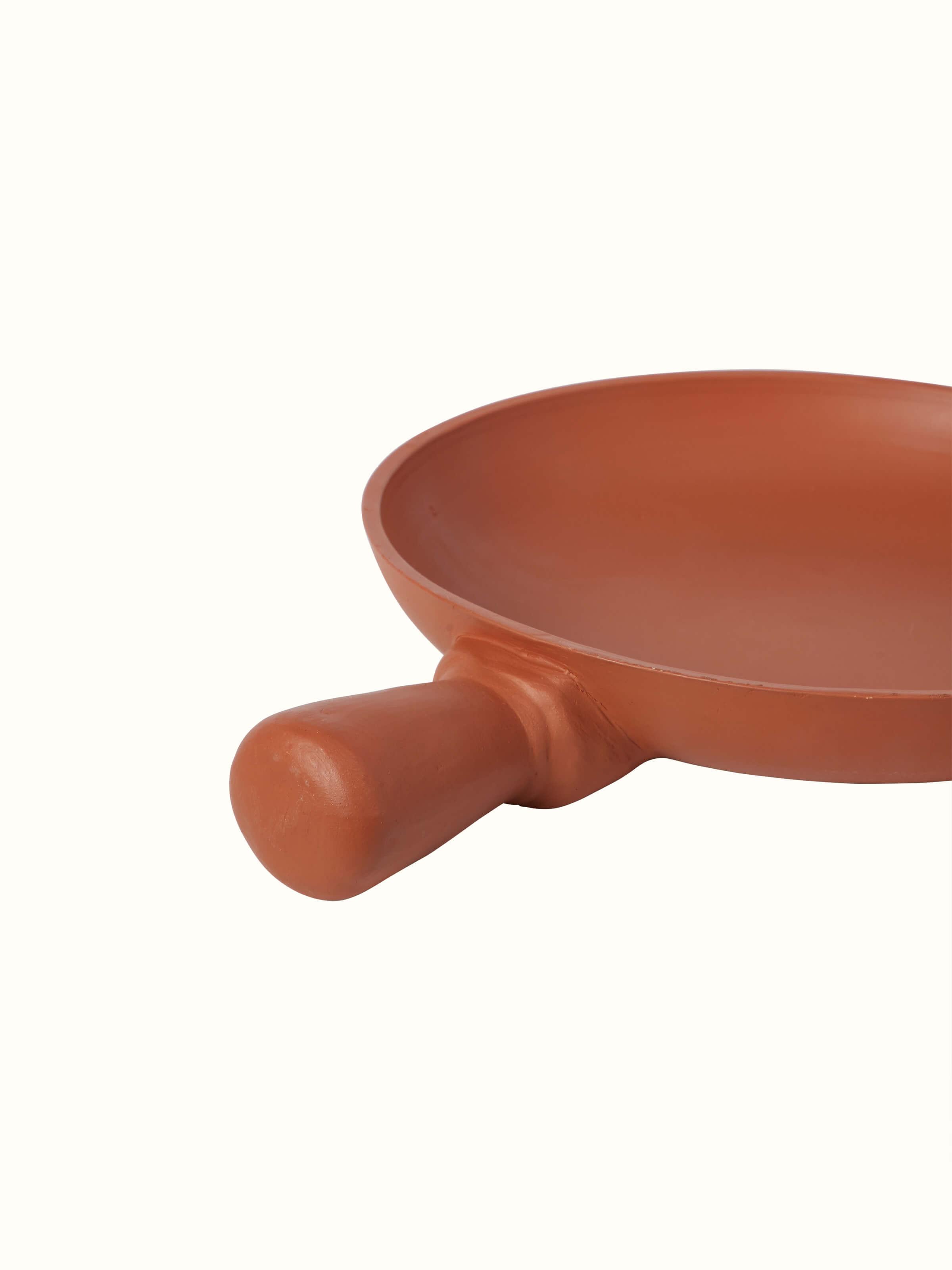 Detailed side view of terracotta clay pan, focusing on the handcrafted finish and design.