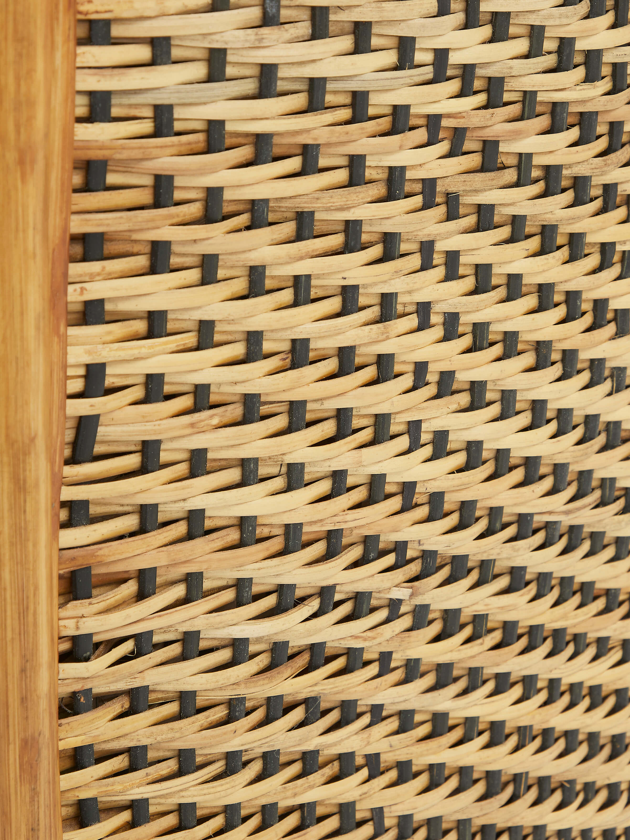 Close-up of Upholstered Cane Armchair armrest showing the texture and detailing of the cane