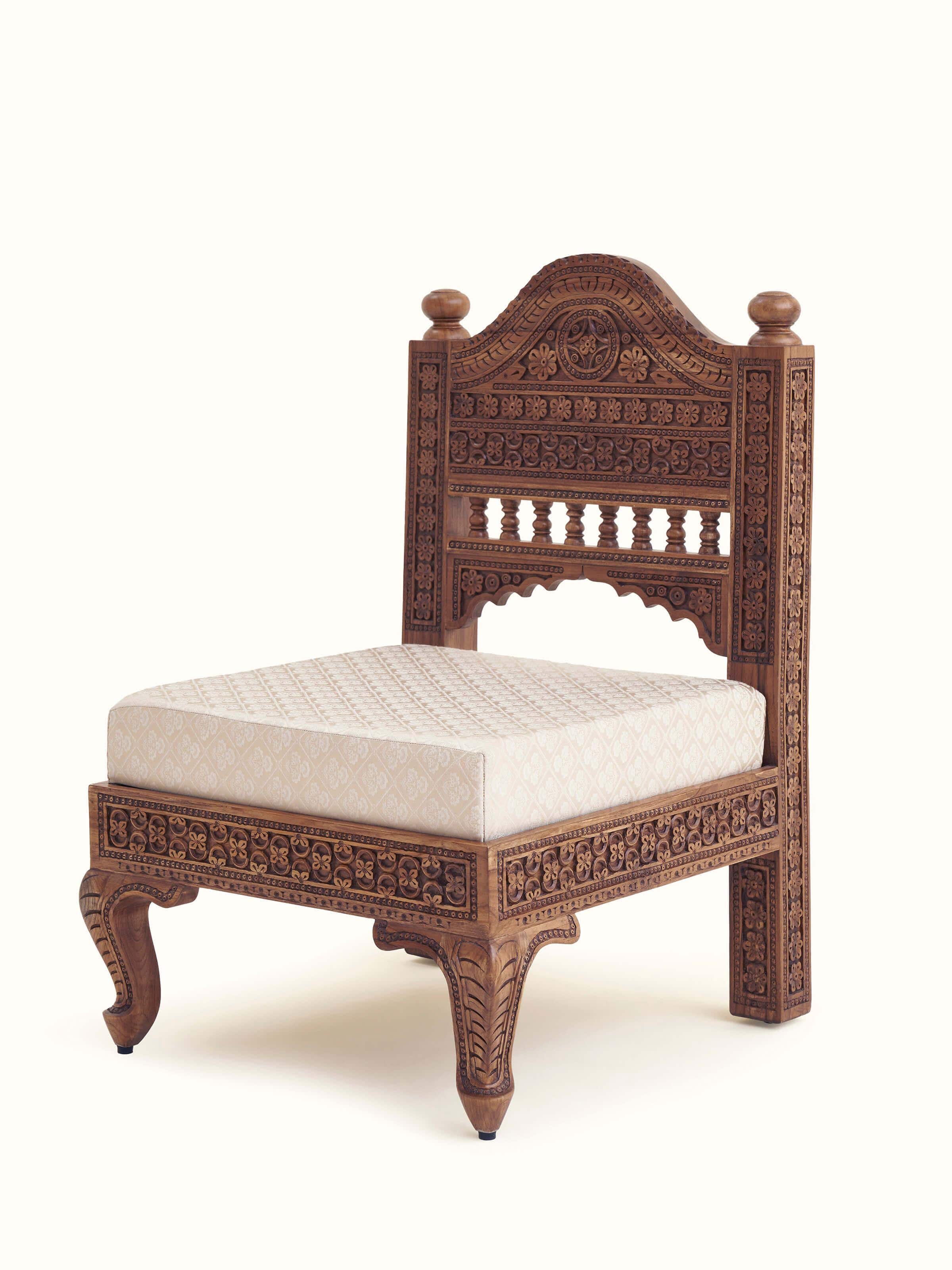 Angle view of Carved Sheesham wood upholstered sofa, highlighting the detailed carvings and elegant fabric