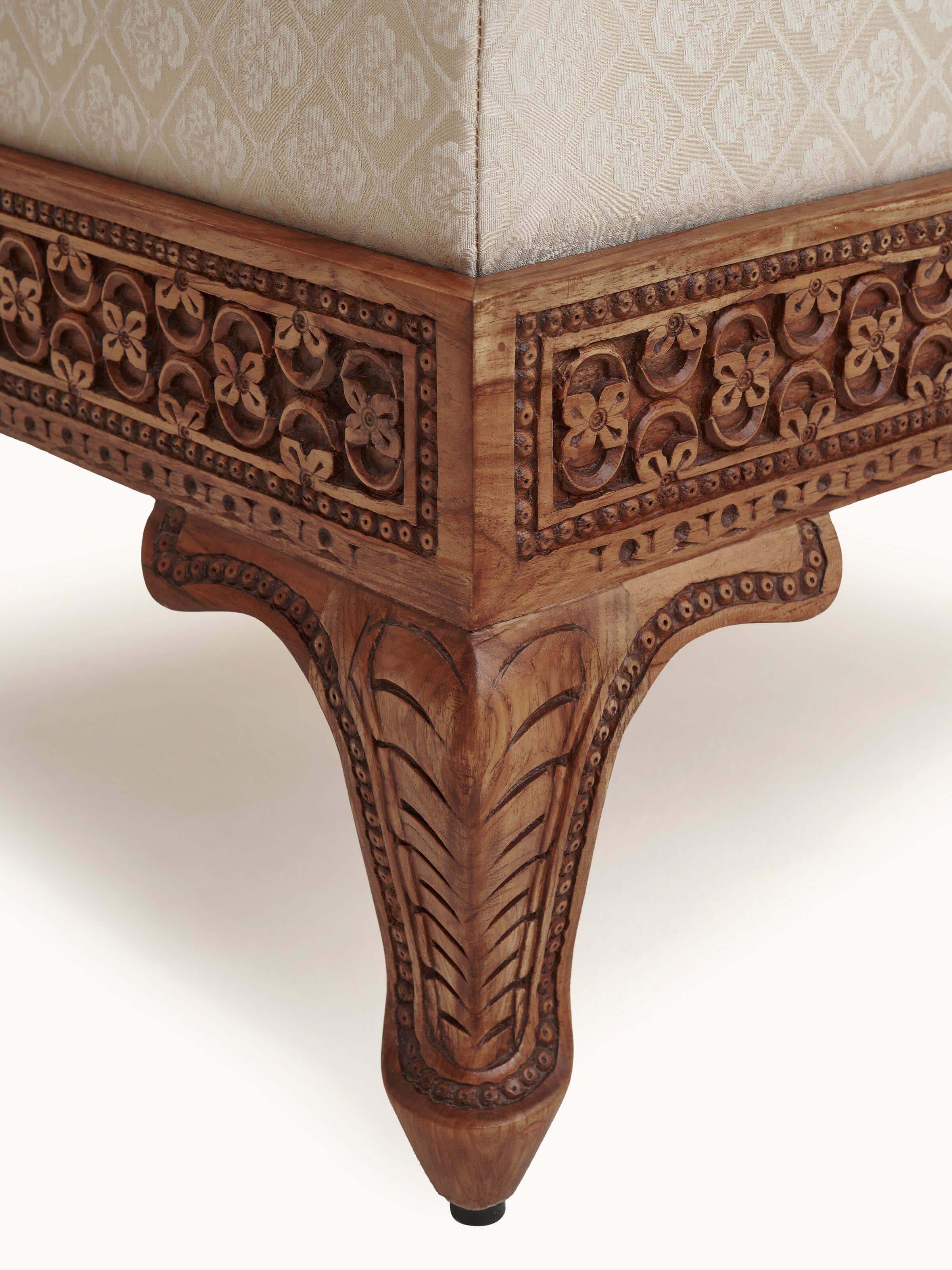 Close-up of Carved Sheesham wood upholstery, emphasizing the craftsmanship of the carvings and quality of the fabric