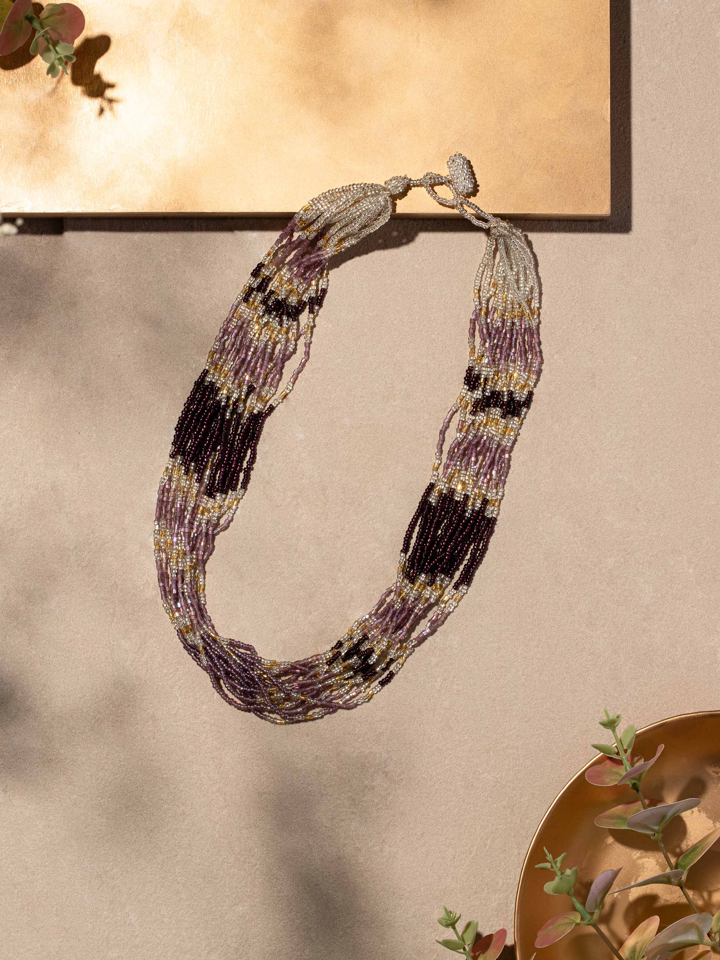 Close-up view of handcrafted long necklace focusing on the fine details and texture.