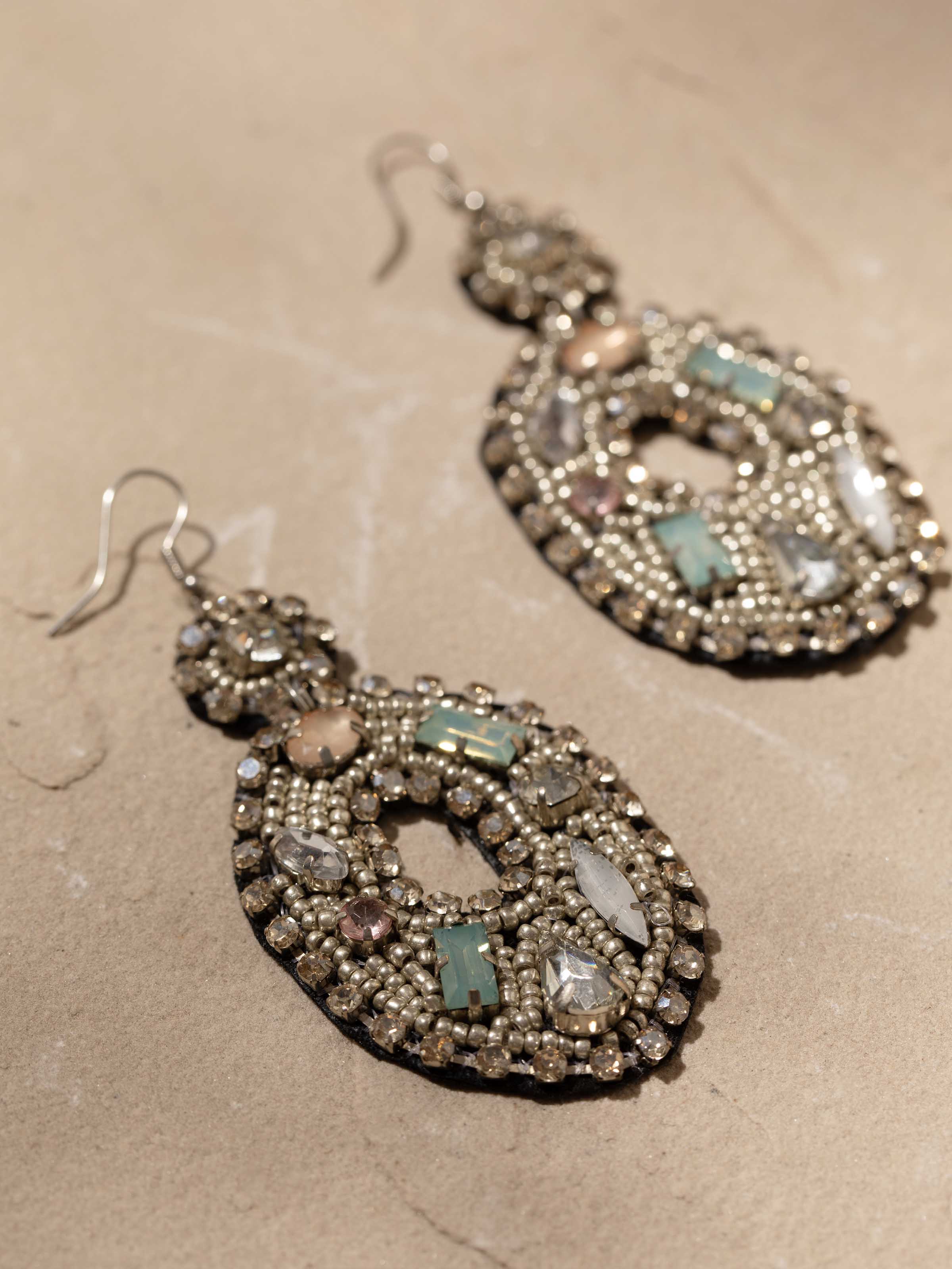 Detailed close-up of handcrafted drop earrings showcasing intricate detailing and texture