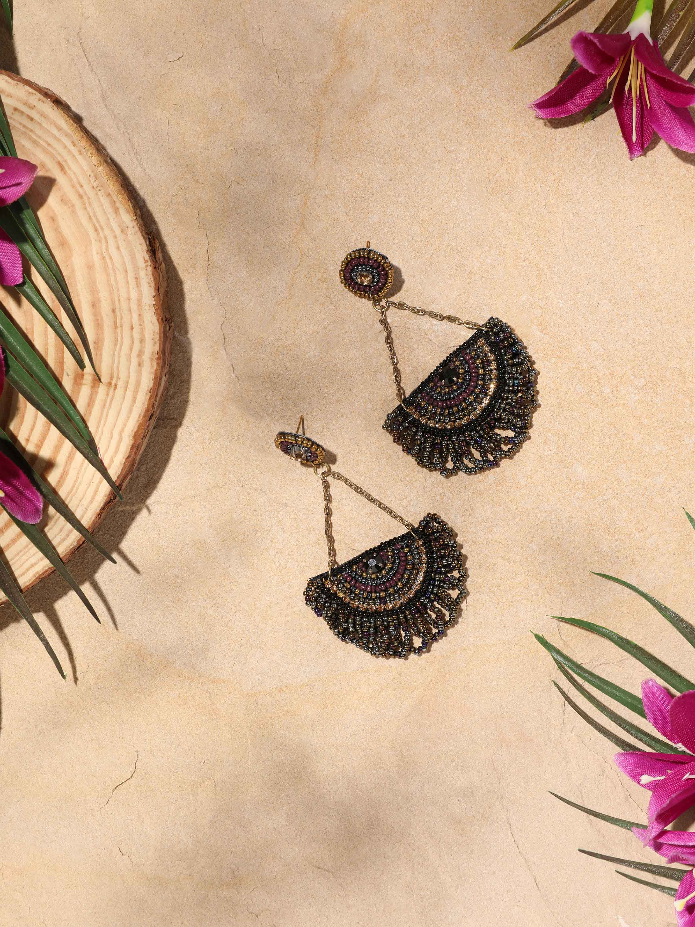 Side view of handcrafted drop earrings showcasing detailed metalwork and design