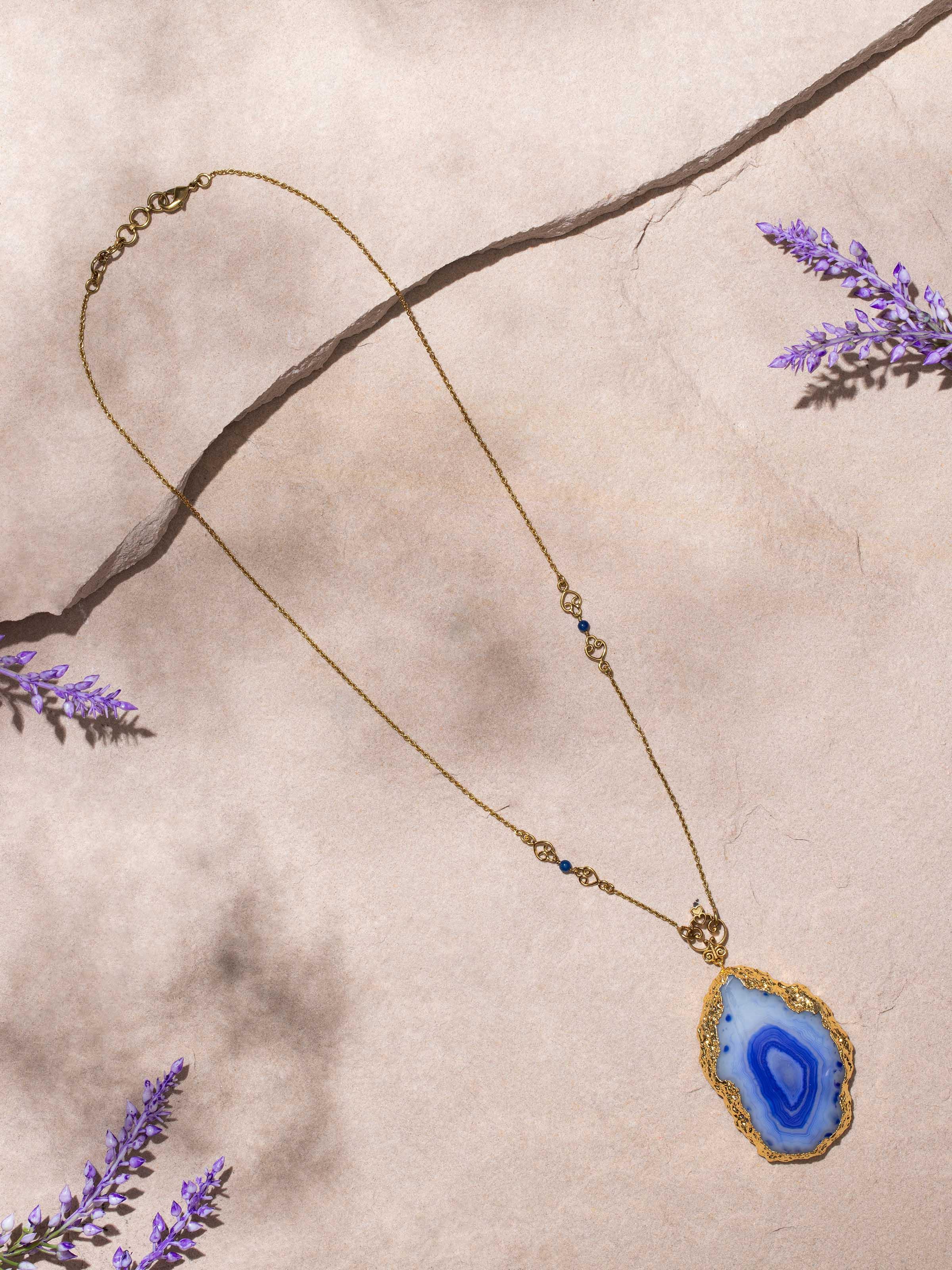 Side view of agate pendant with chain showing the pendant’s smooth finish.