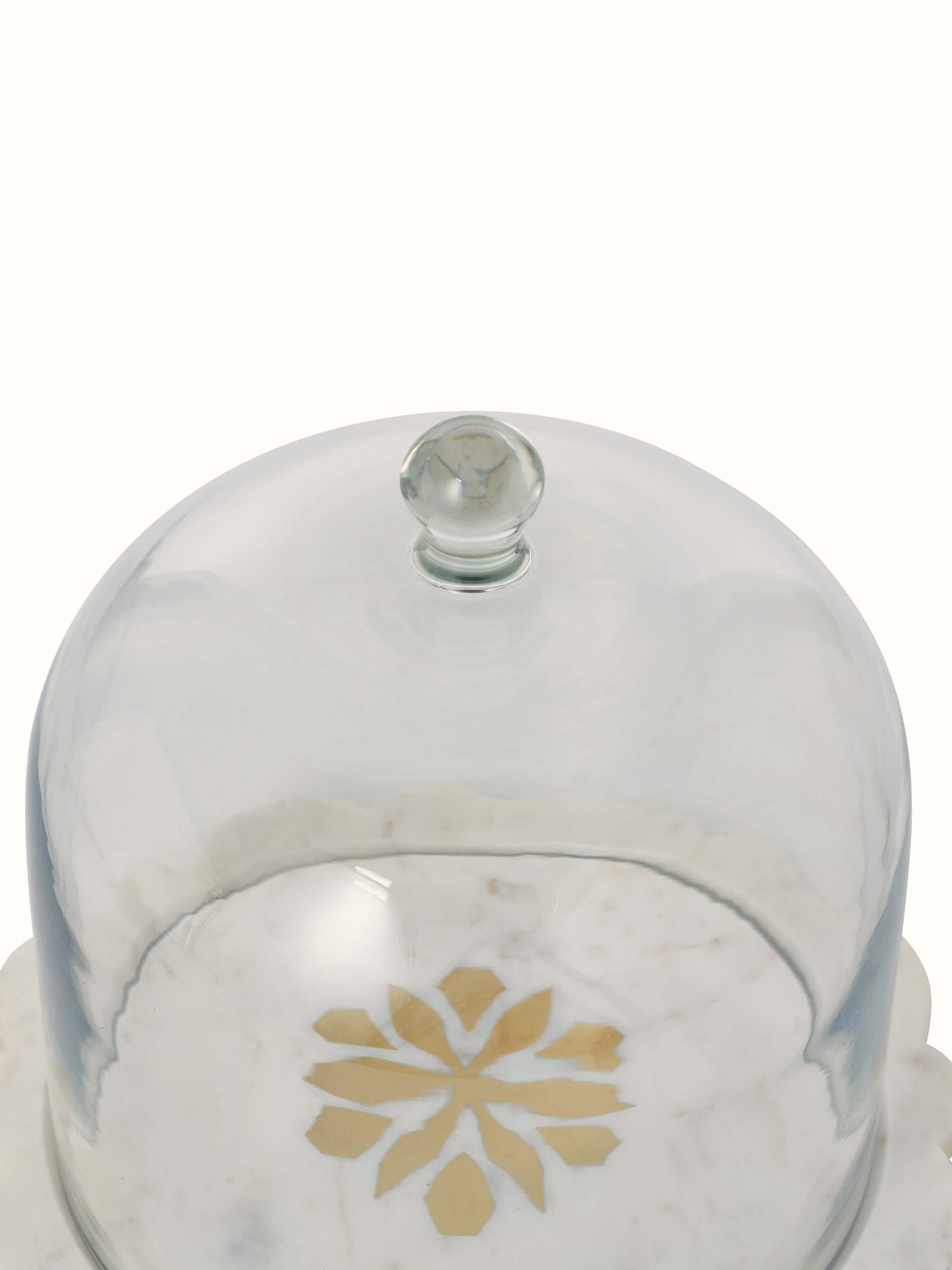 Angled view of carved marble and glass cloche showcasing its sophisticated design