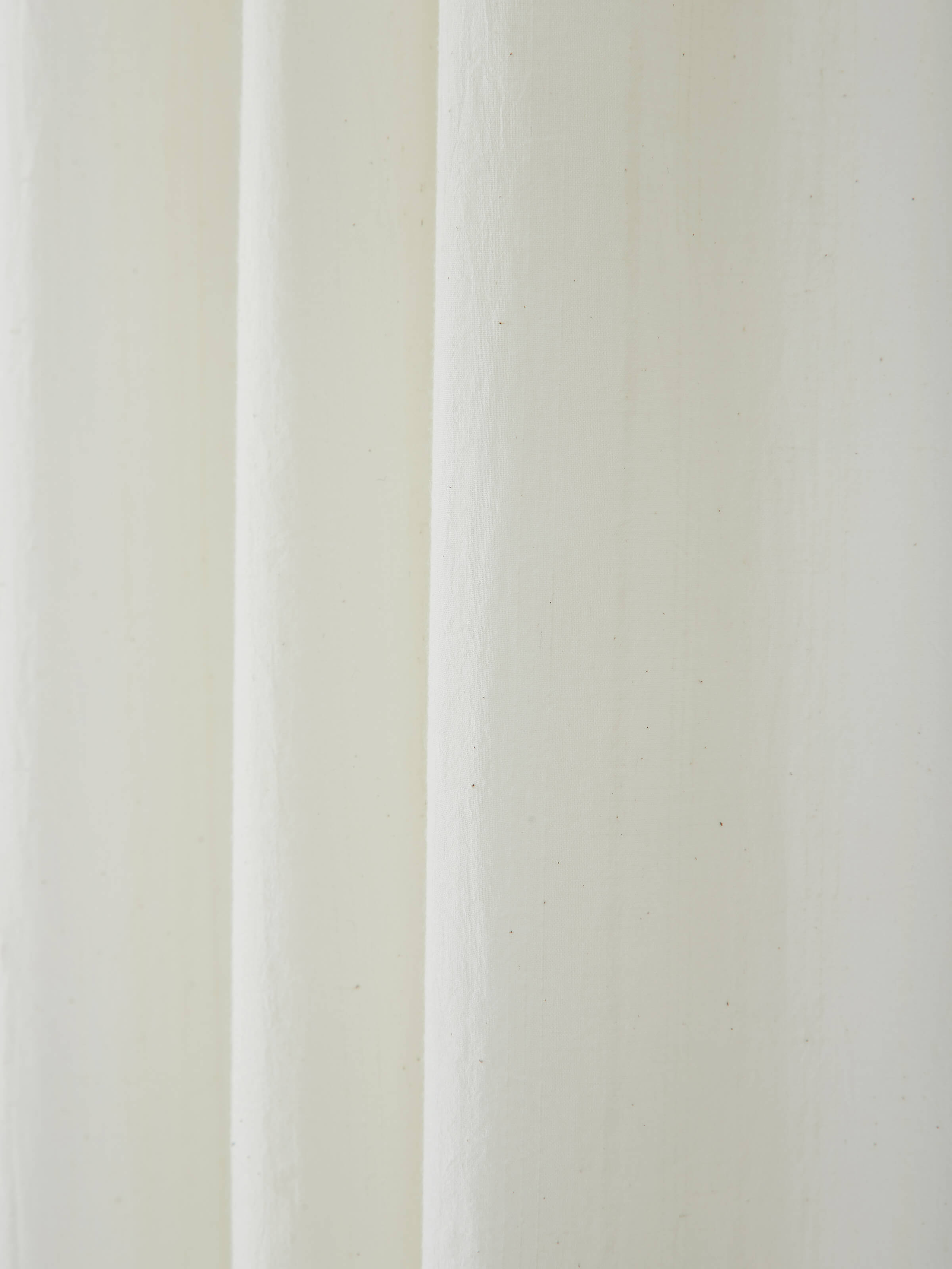 Perspective view of Kapasa off-white solid handloom cotton curtain (9 ft) displaying the curtain’s length and color.