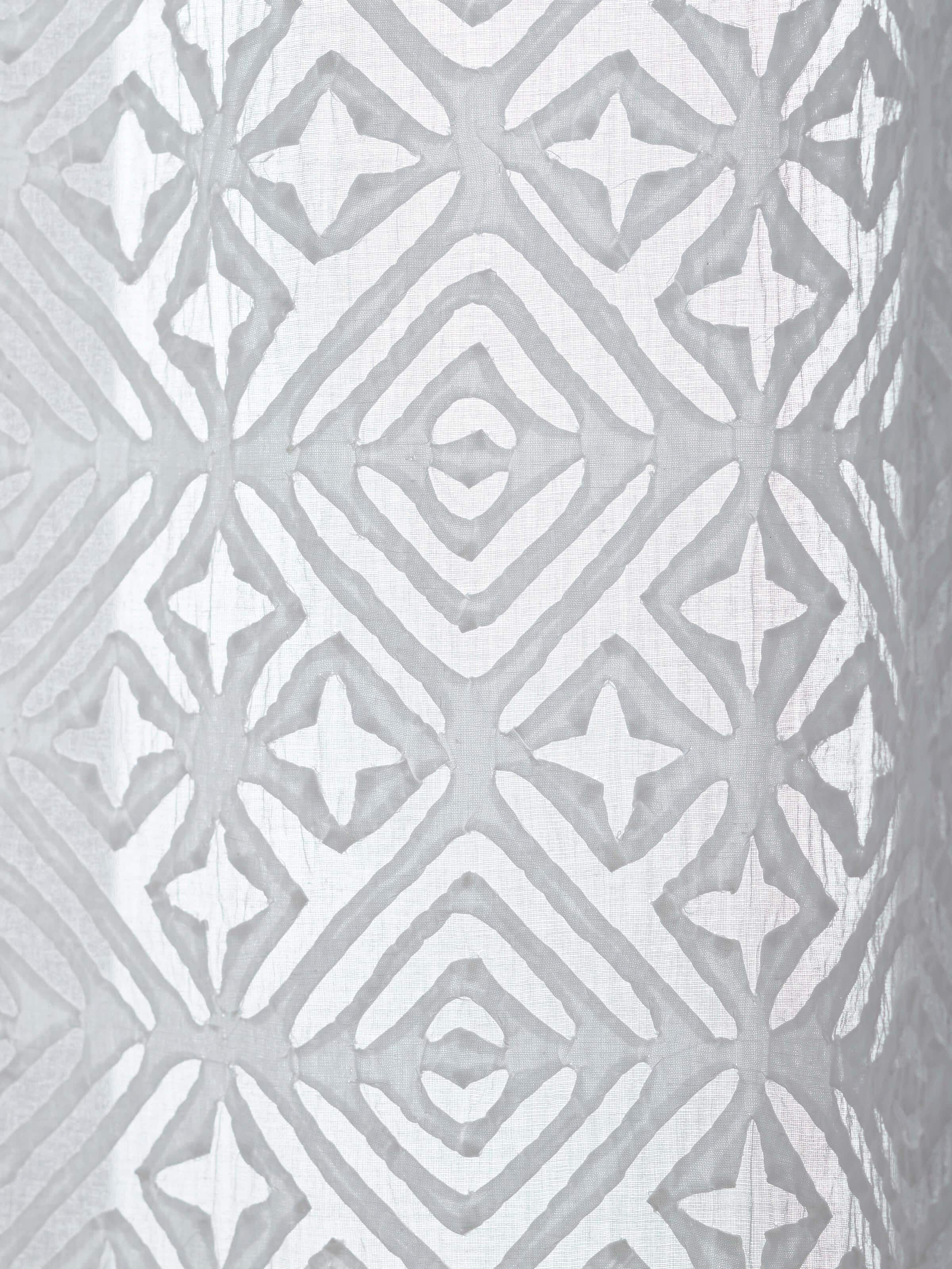 Mandana White Trellis sheer curtain hanging in a room, showcasing its elegant and airy design