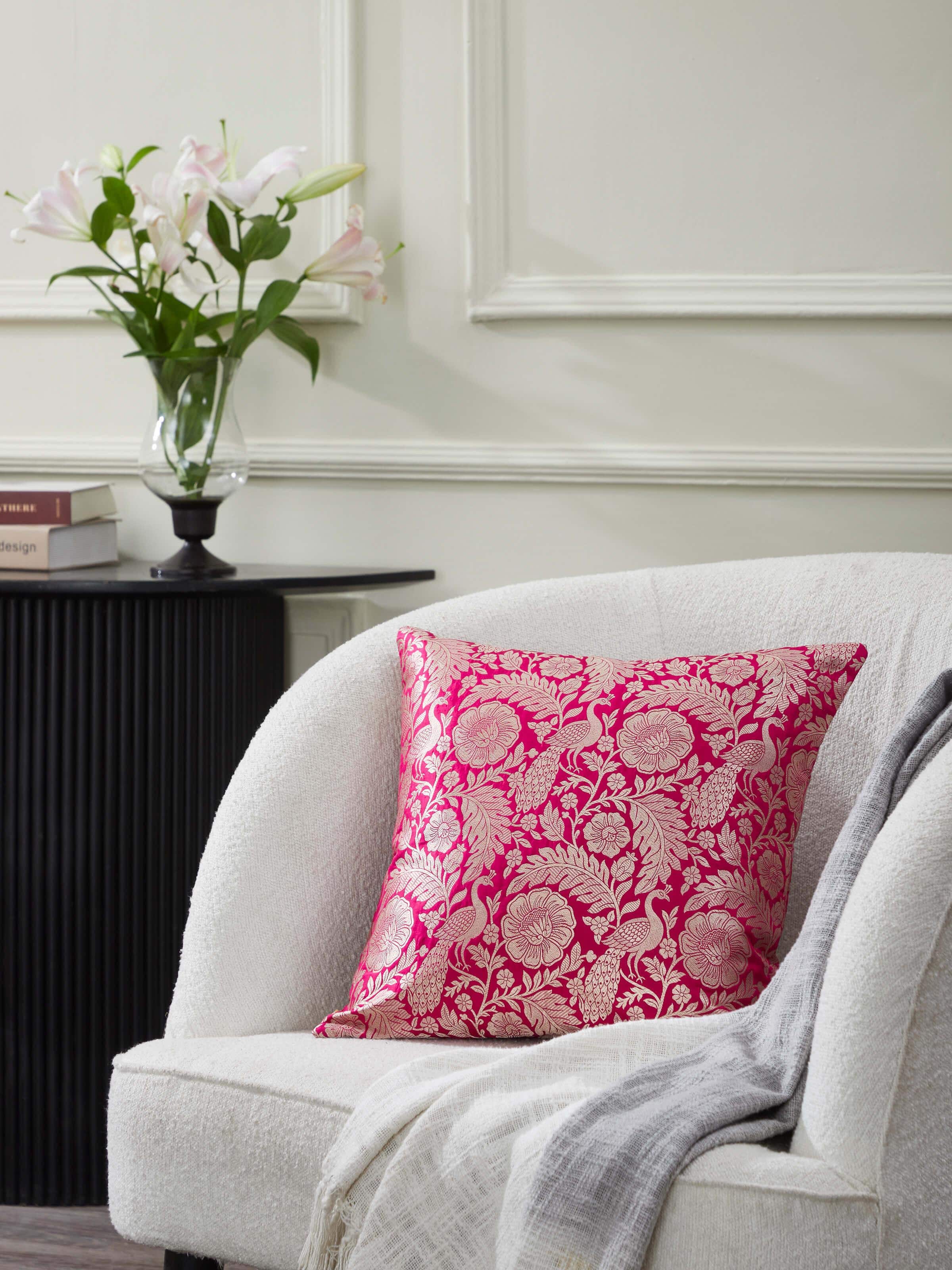 Close-up of Avasa raspberry floral silk brocade Banarasi handloom cushion cover showing the intricate brocade work and floral design.