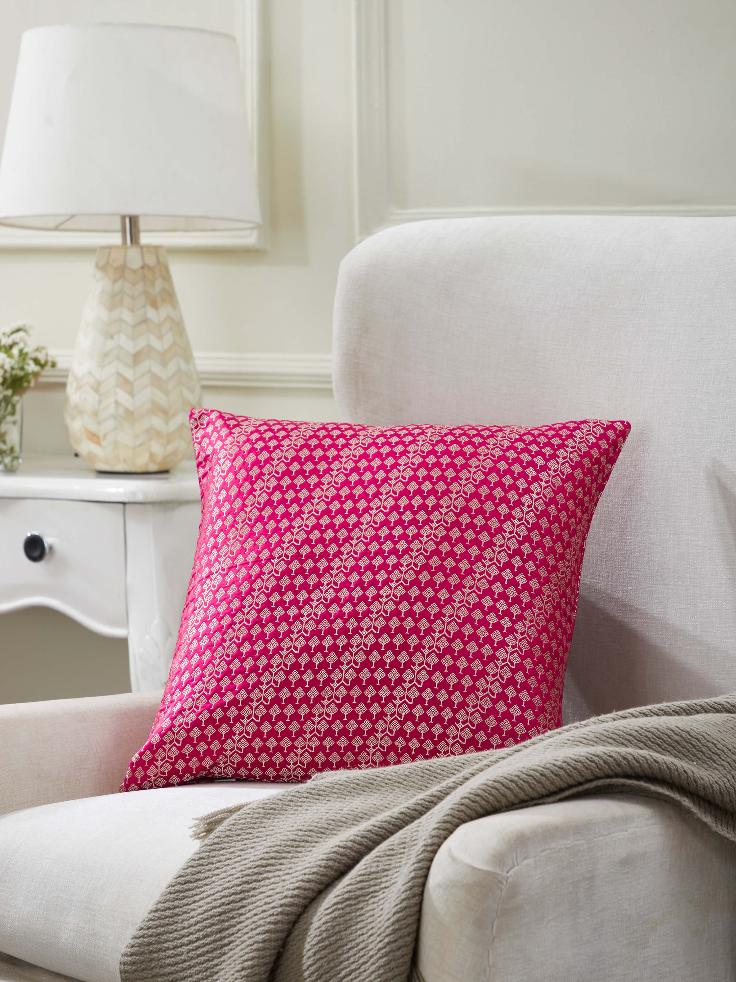 Lifestyle image of Avasa handloom silk cushion styled in an elegant interior setting