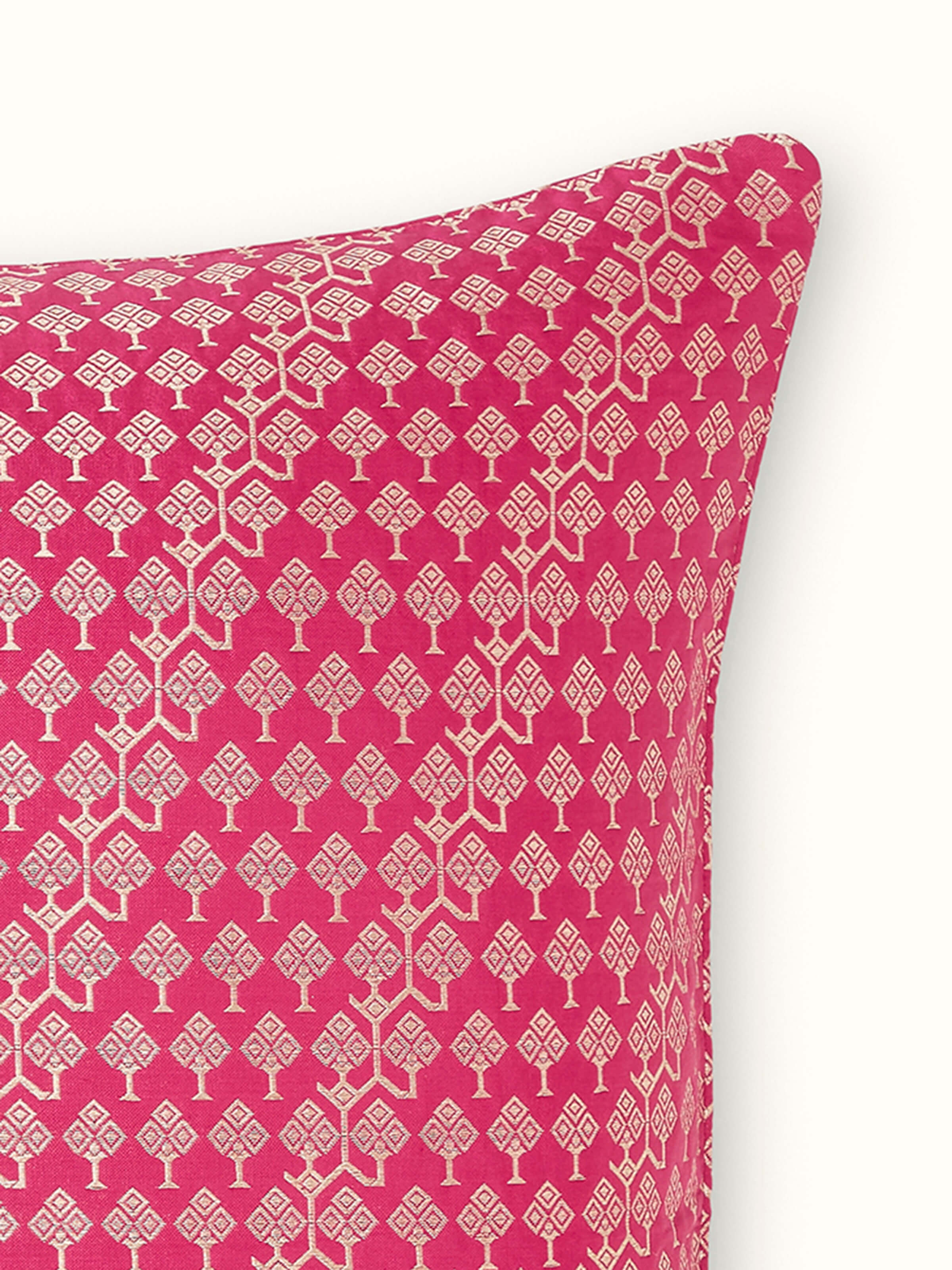 Detail view of handloom brocade design in metallic threads over pink silk base